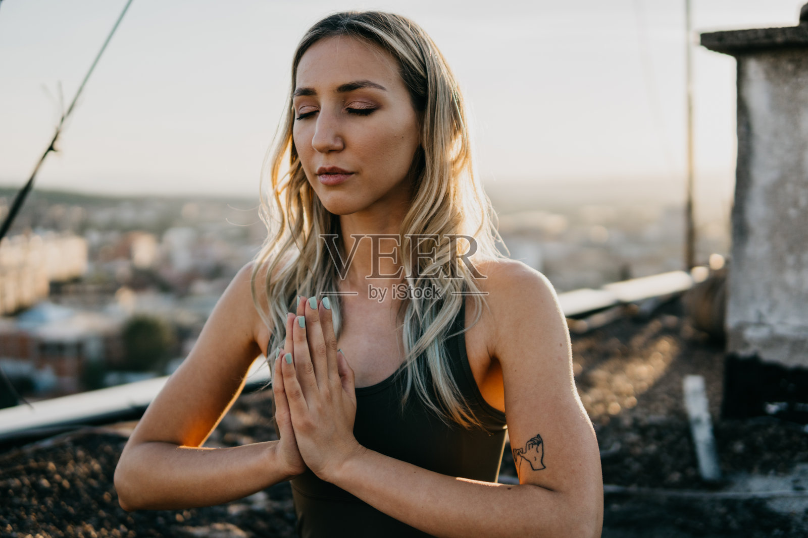有个年轻漂亮的女人在屋顶上做瑜伽照片摄影图片