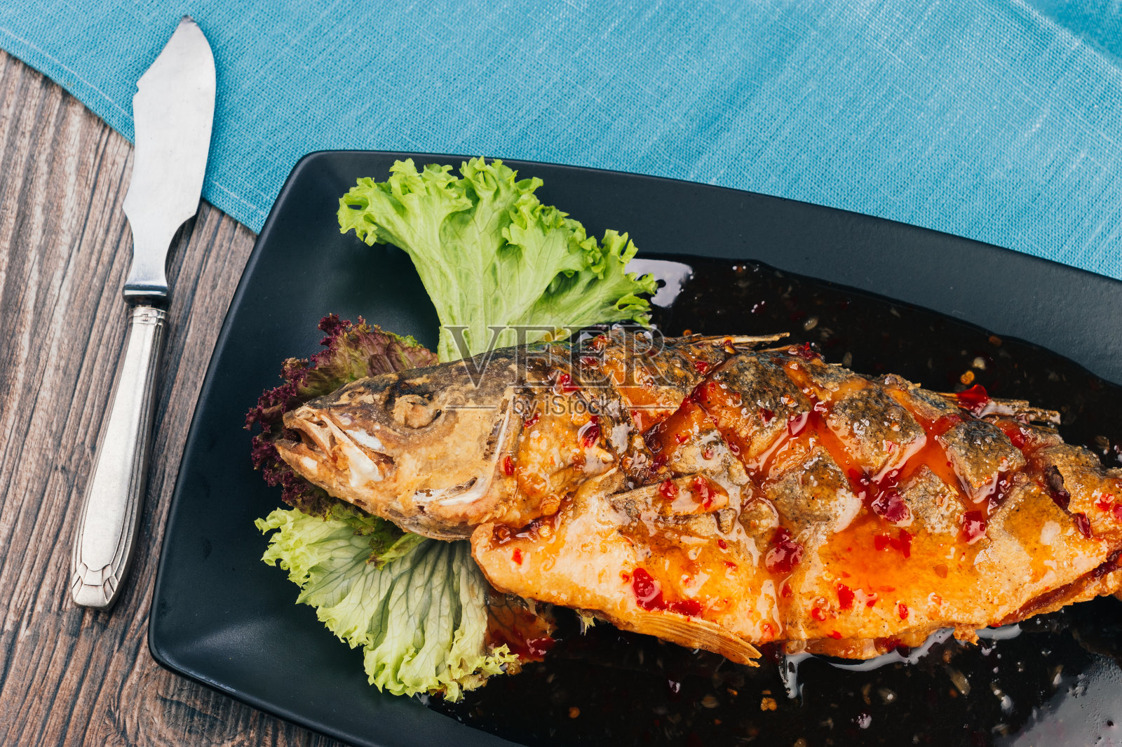 新鲜烹制的鲈鱼，配上调味料和青菜沙拉照片摄影图片