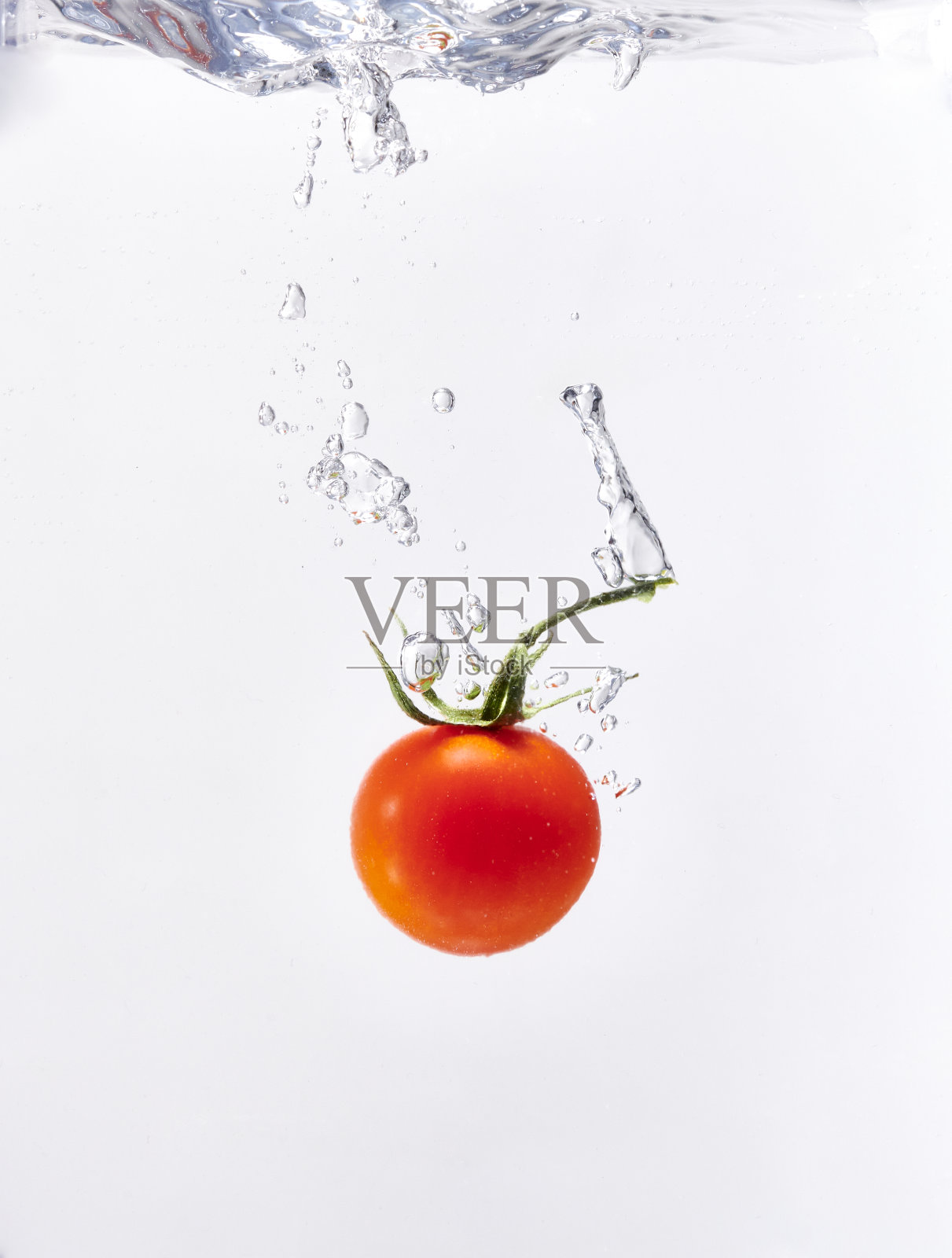 新鲜的樱桃番茄投入水中照片摄影图片