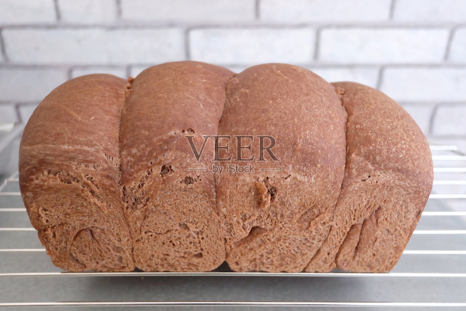 选择焦点自制的巧克力面包在食物格栅和厨房白砖墙的背景照片摄影图片