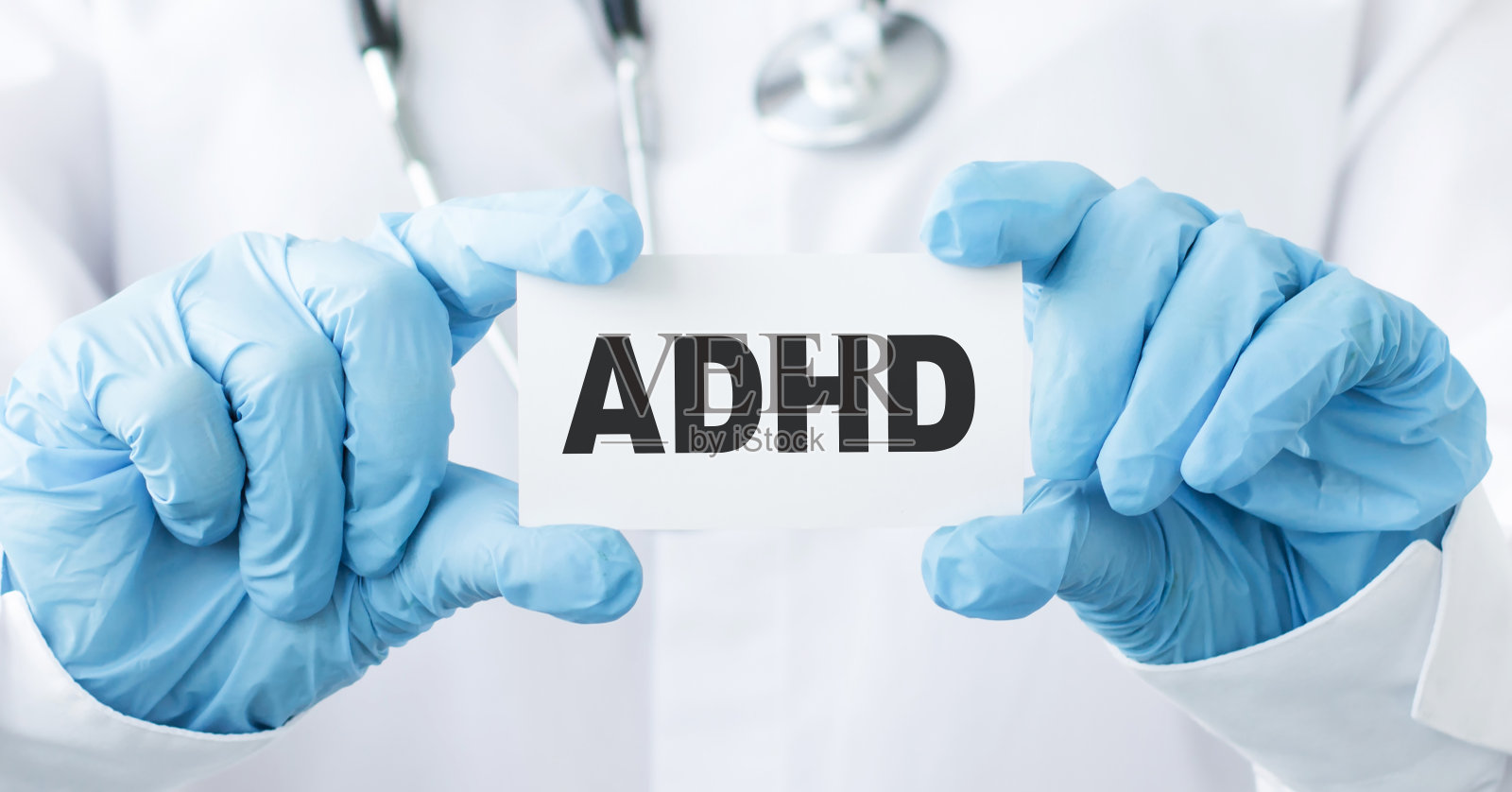 医生拿着一张写有ADHD的卡片，医疗概念。照片摄影图片