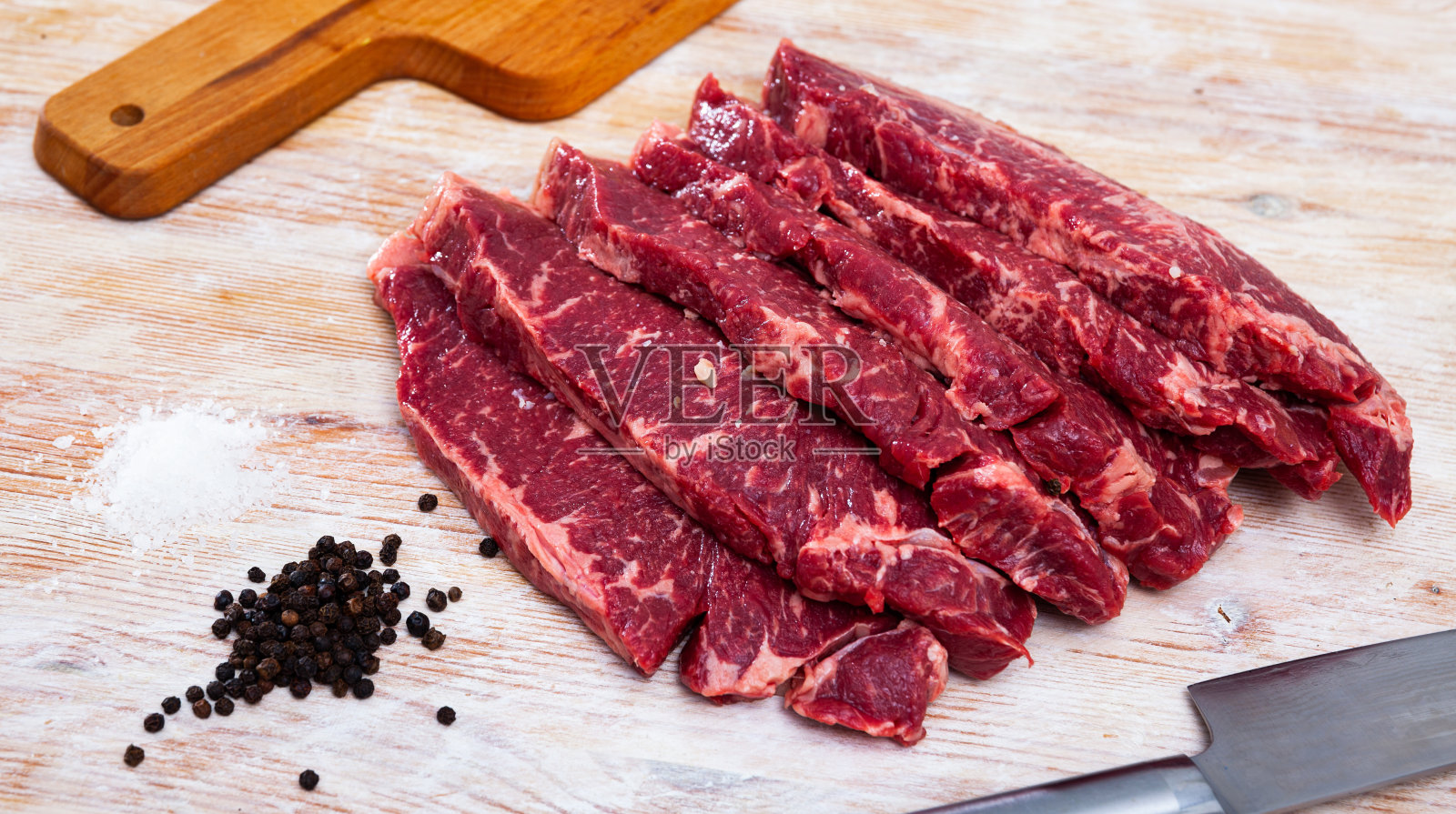 切成薄片的生大理石牛肉和胡椒粒照片摄影图片