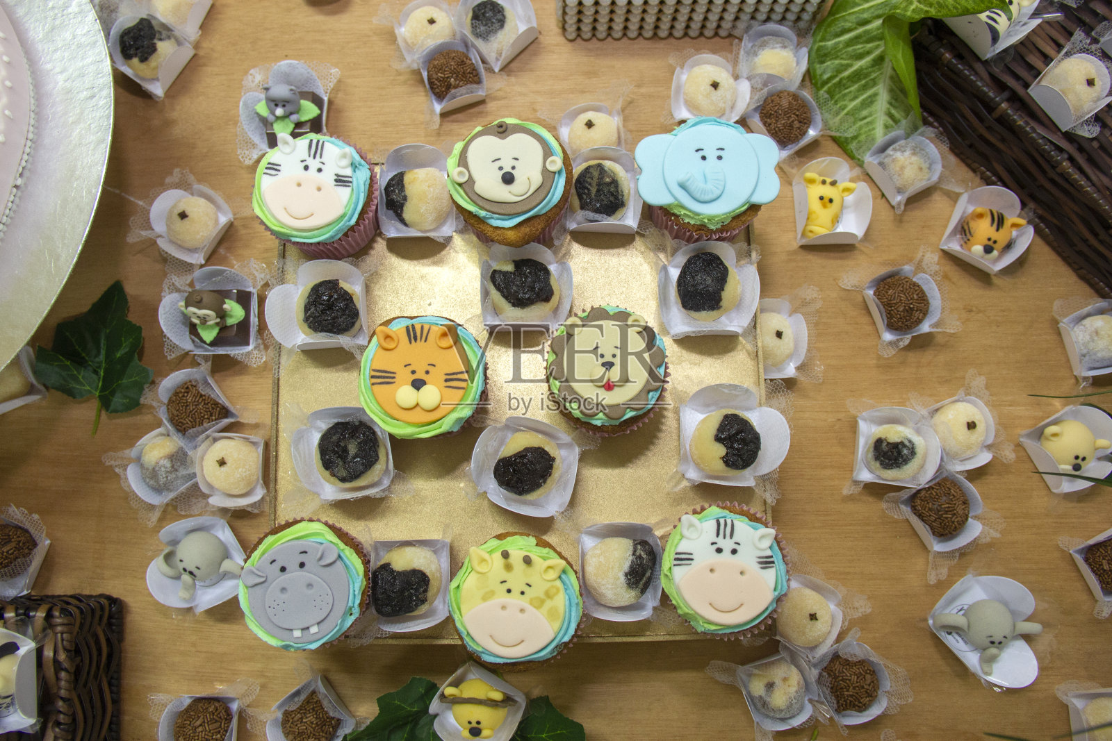 纸杯蛋糕用儿童的动物和巧克力糖果装饰和brigadeiro在儿童聚会桌上的装饰照片摄影图片