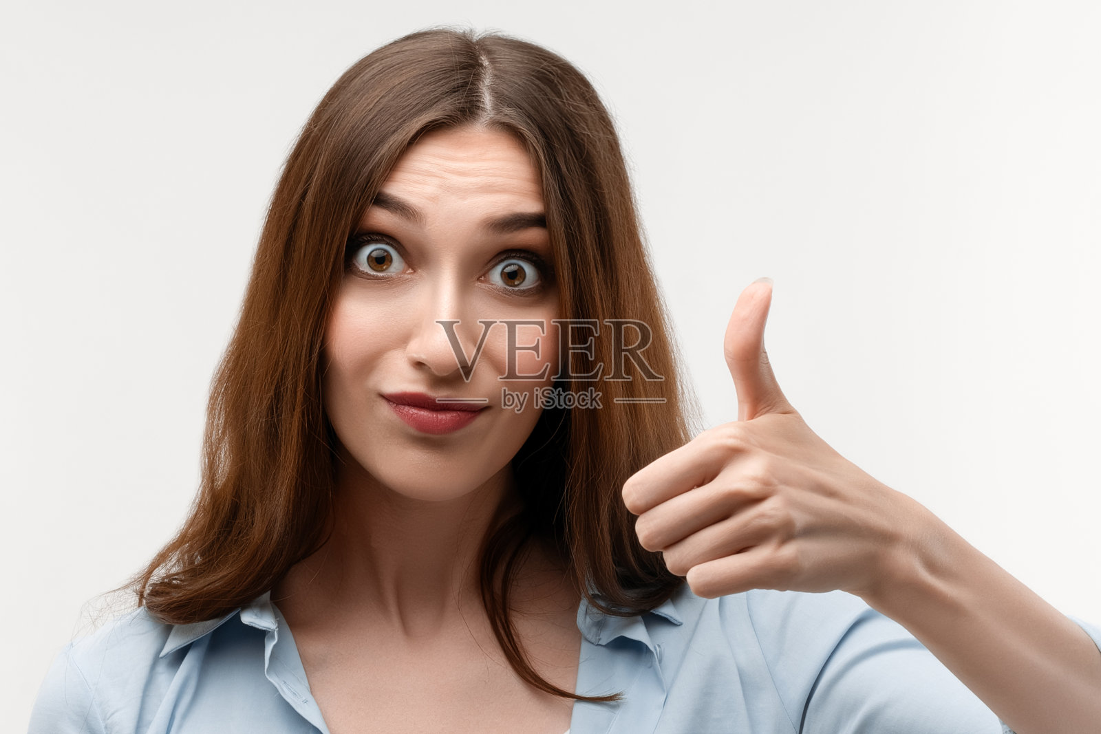 近距离观察长栗色头发的年轻白人女性，用手示意“ok”，表示同意照片摄影图片
