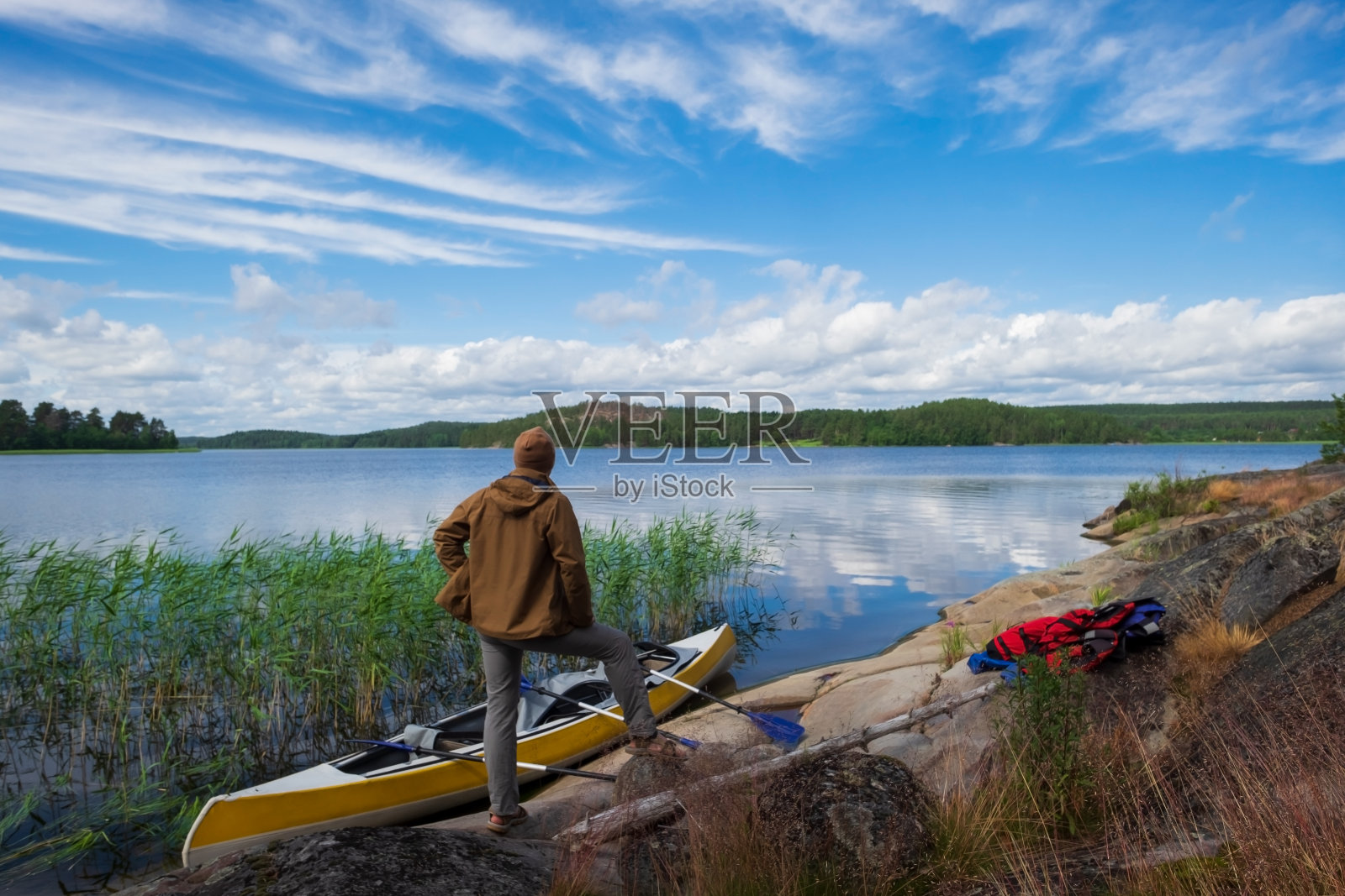 一名男子在划船后站在河边休息照片摄影图片