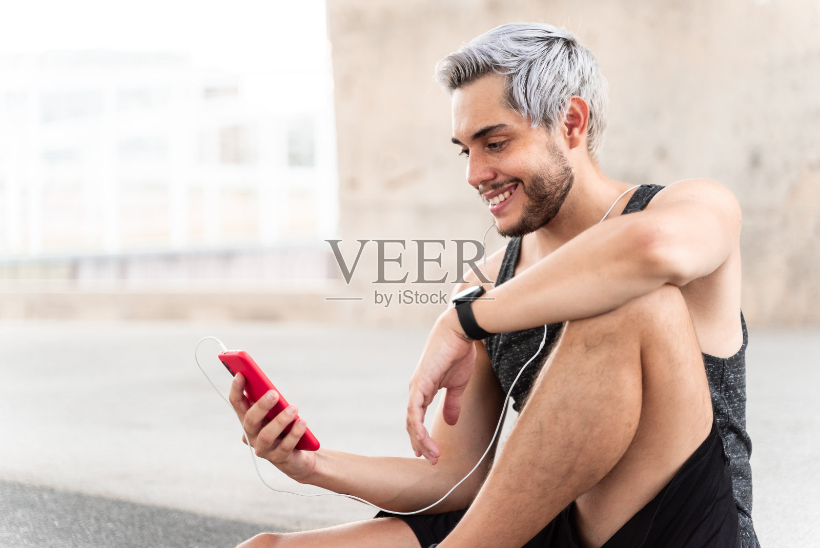 千禧一代健身者一边锻炼一边用智能手机听音乐。健康的概念照片摄影图片