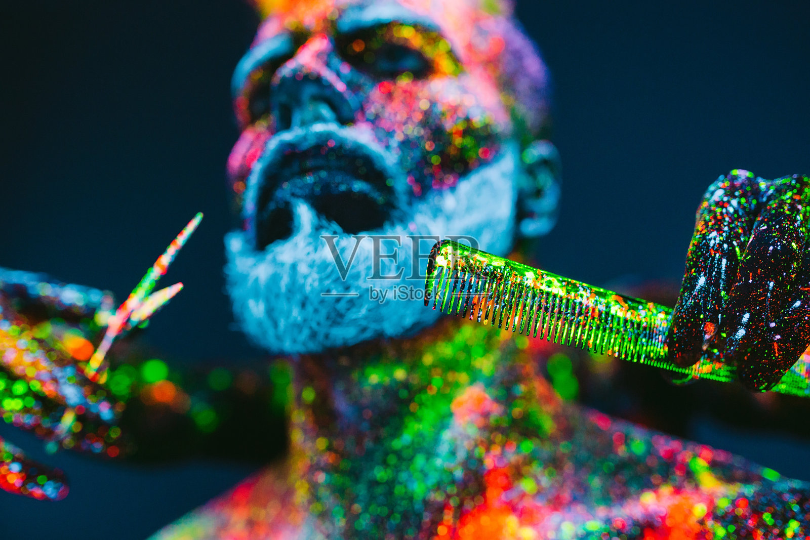 的概念。理发店里的大胡子男人。一个留着时髦胡子的男人正在理发店里理发。这个人用紫外线粉做装饰照片摄影图片