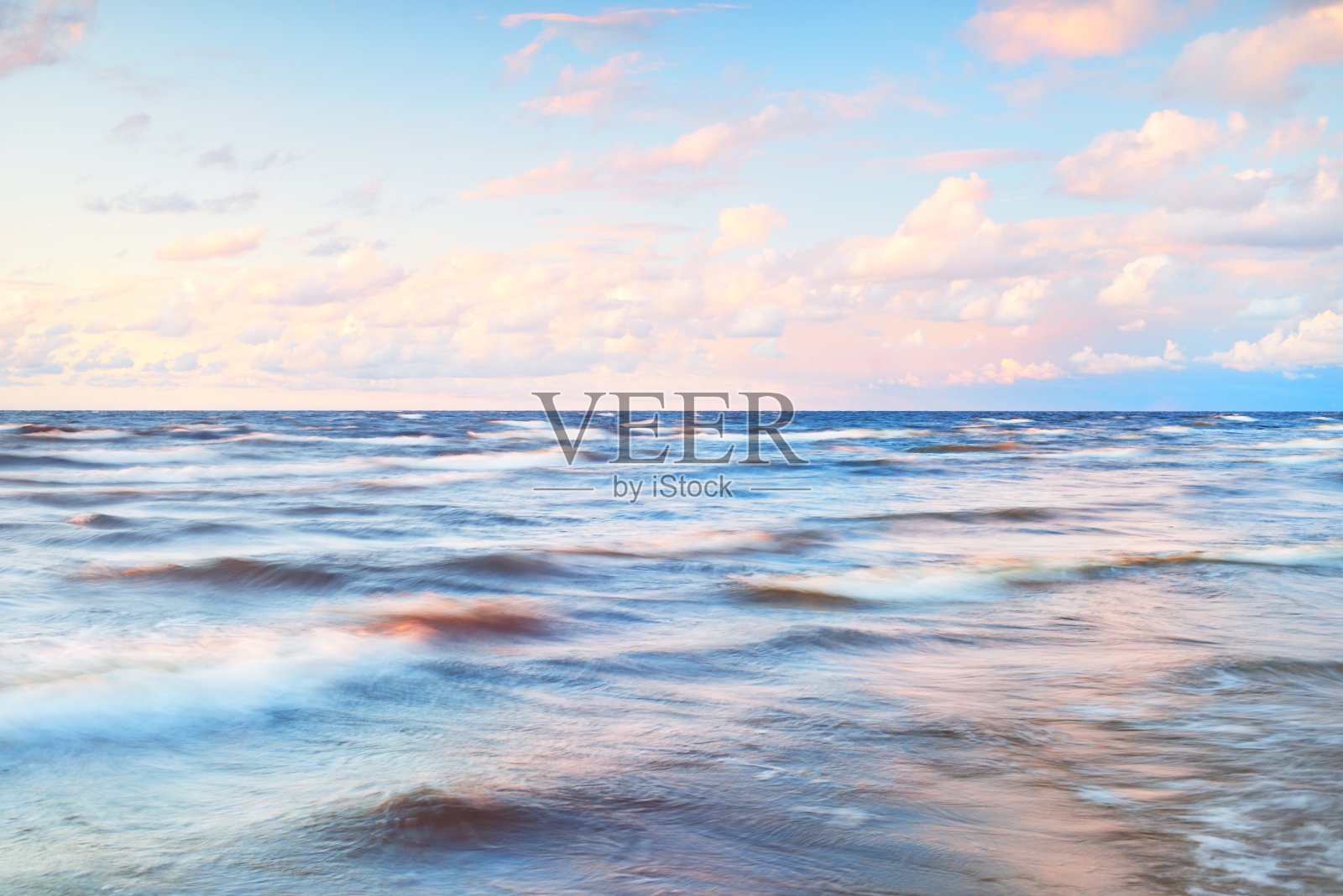 史诗色彩斑斓的粉红色晚霞在雷雨后的海面上。戏剧性的天空。波浪和水溅纹理。田园诗般的海景。概念形象，长曝光。风景如画的风景照片摄影图片