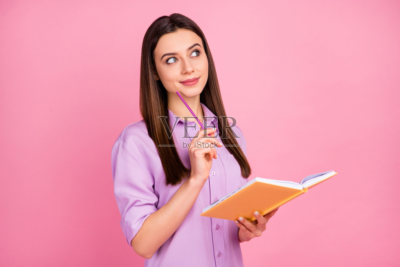 她的特写肖像，她漂亮，迷人，可爱，漂亮，聪明，专注，快乐，梦幻的长发女孩写创造笔记孤立在粉红色柔和的颜色背景照片摄影图片