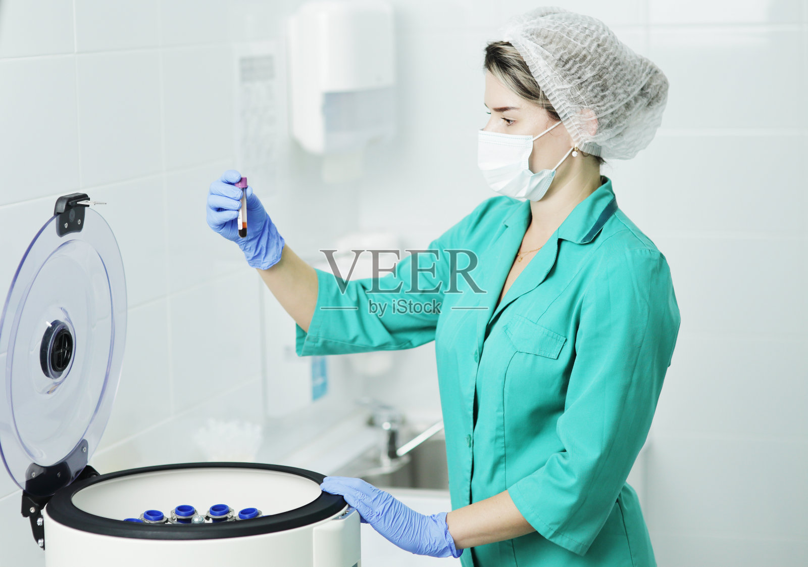 一位戴医用口罩的女护士拿着一根试管进行血液测试照片摄影图片