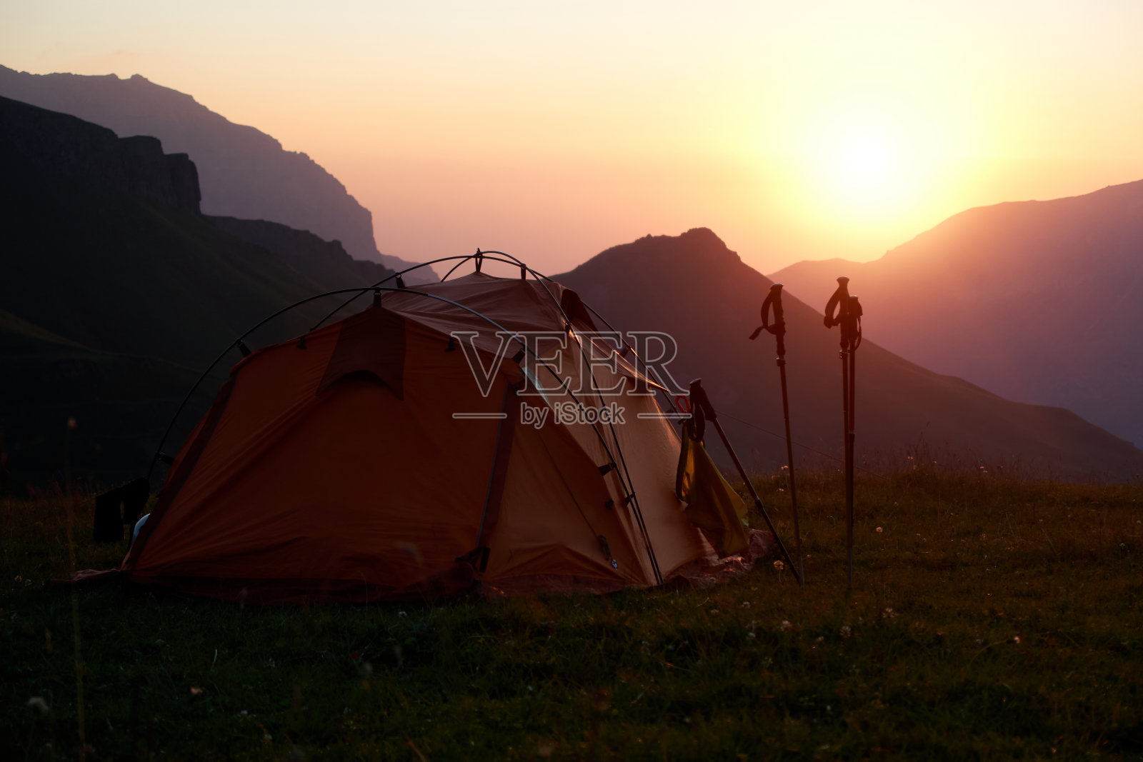 日出时群山背景下的旅游帐篷。照片摄影图片