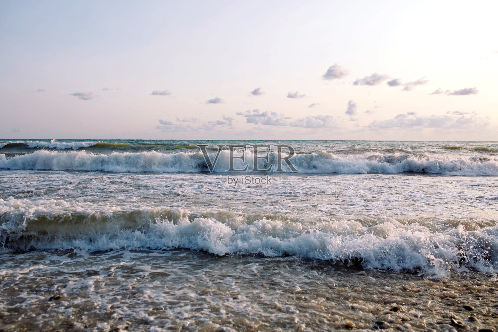日落海滩。海岸上吹着海风。照片摄影图片