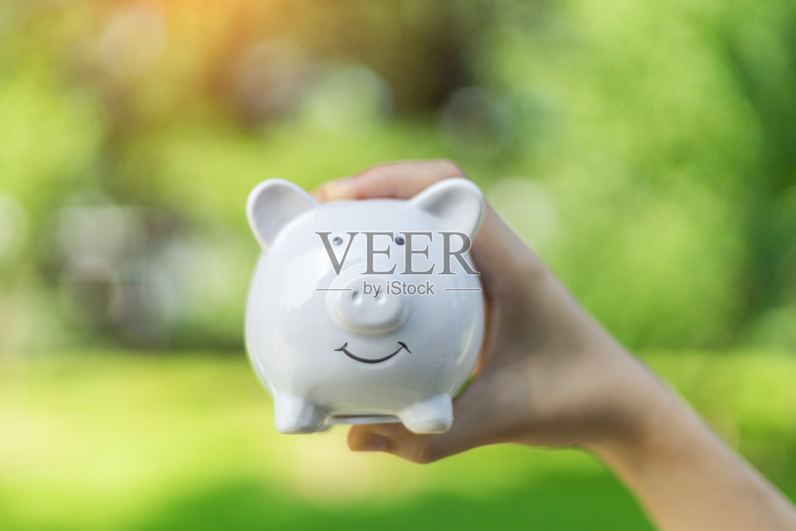 抱着小猪储蓄罐的自然背景照片摄影图片