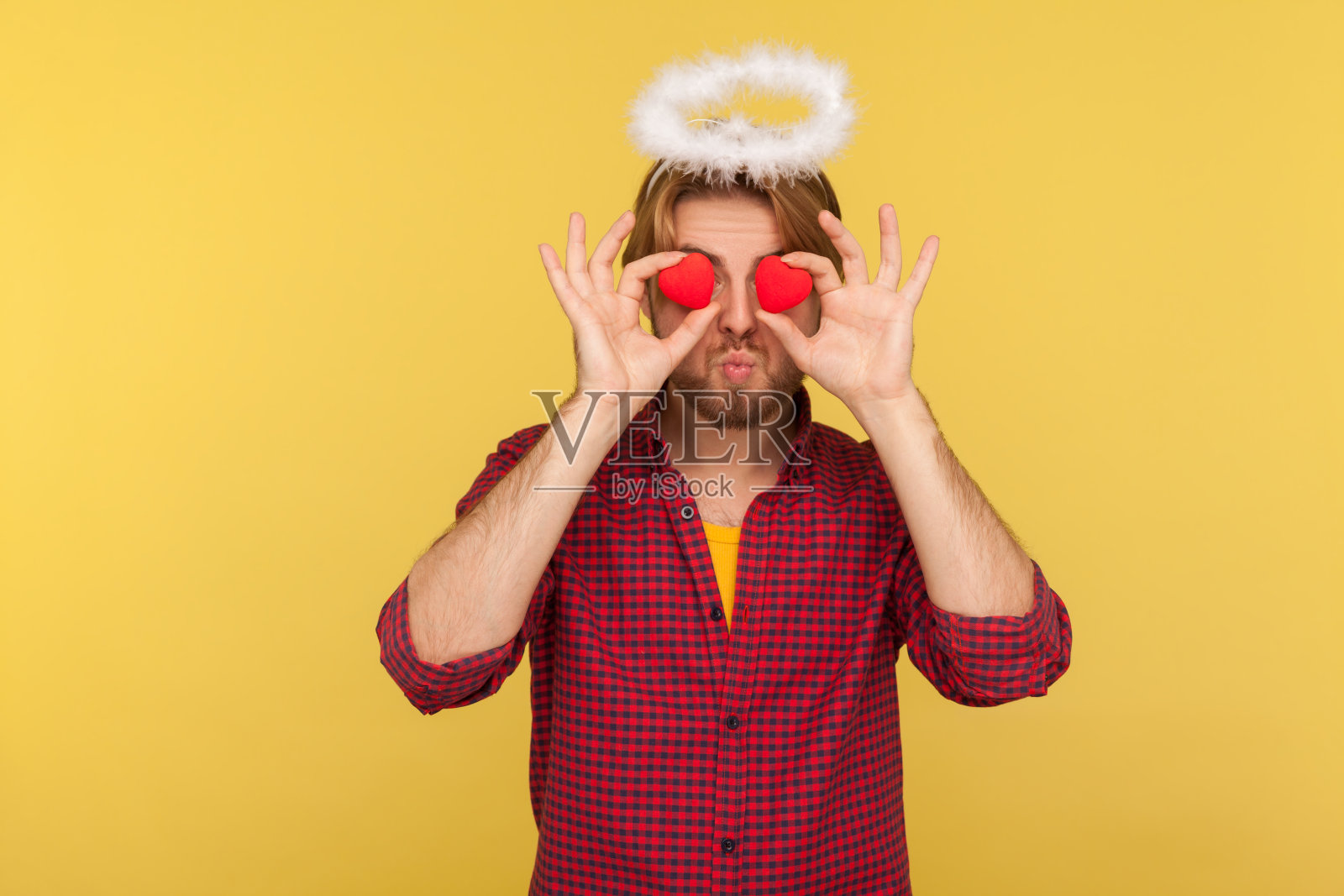 浪漫的大胡子男圣人光环覆盖眼睛与玩具心仿佛看着与爱，送飞吻，概念的感情照片摄影图片