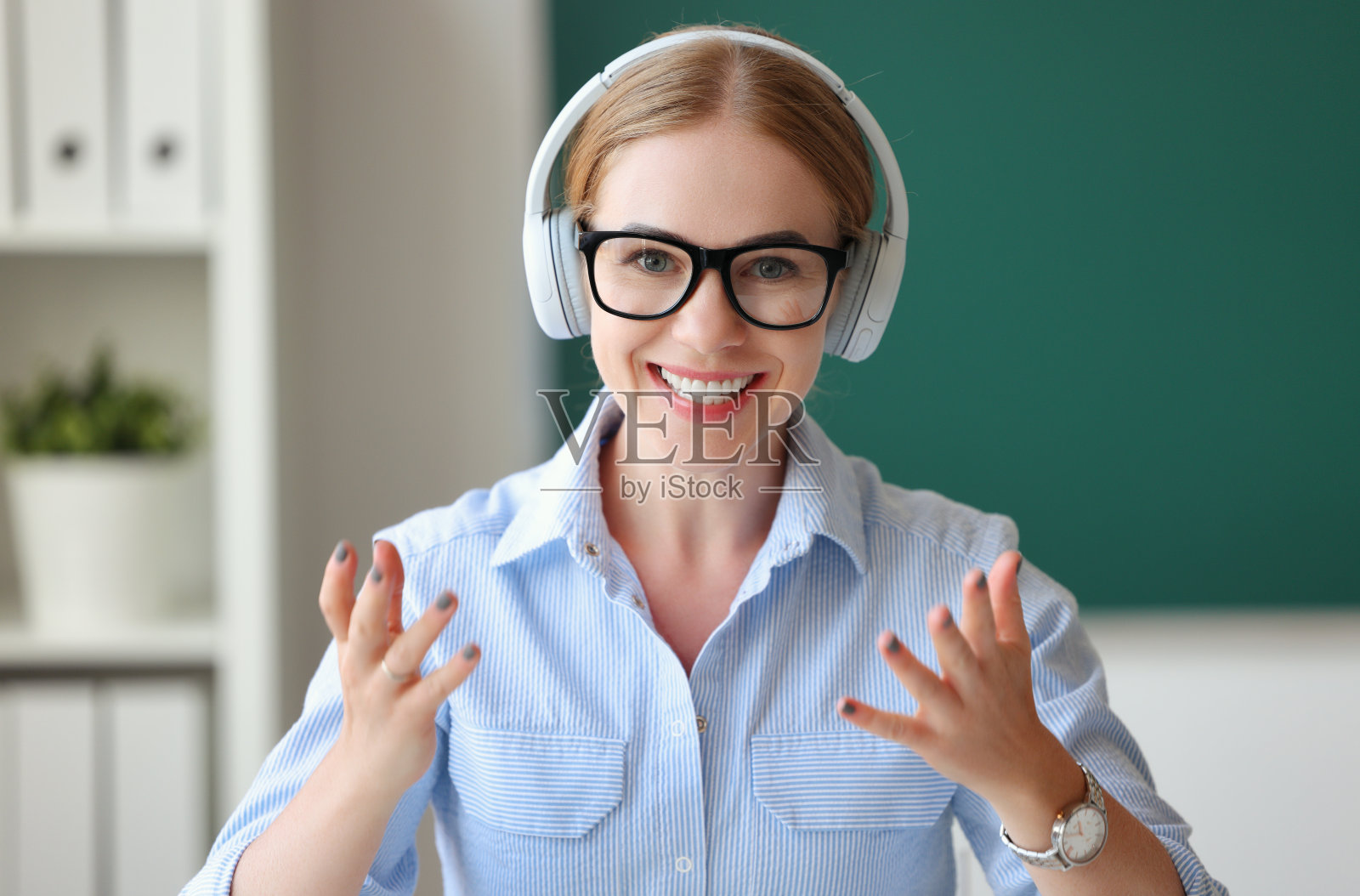 友善的老师戴着耳机看着摄像机照片摄影图片