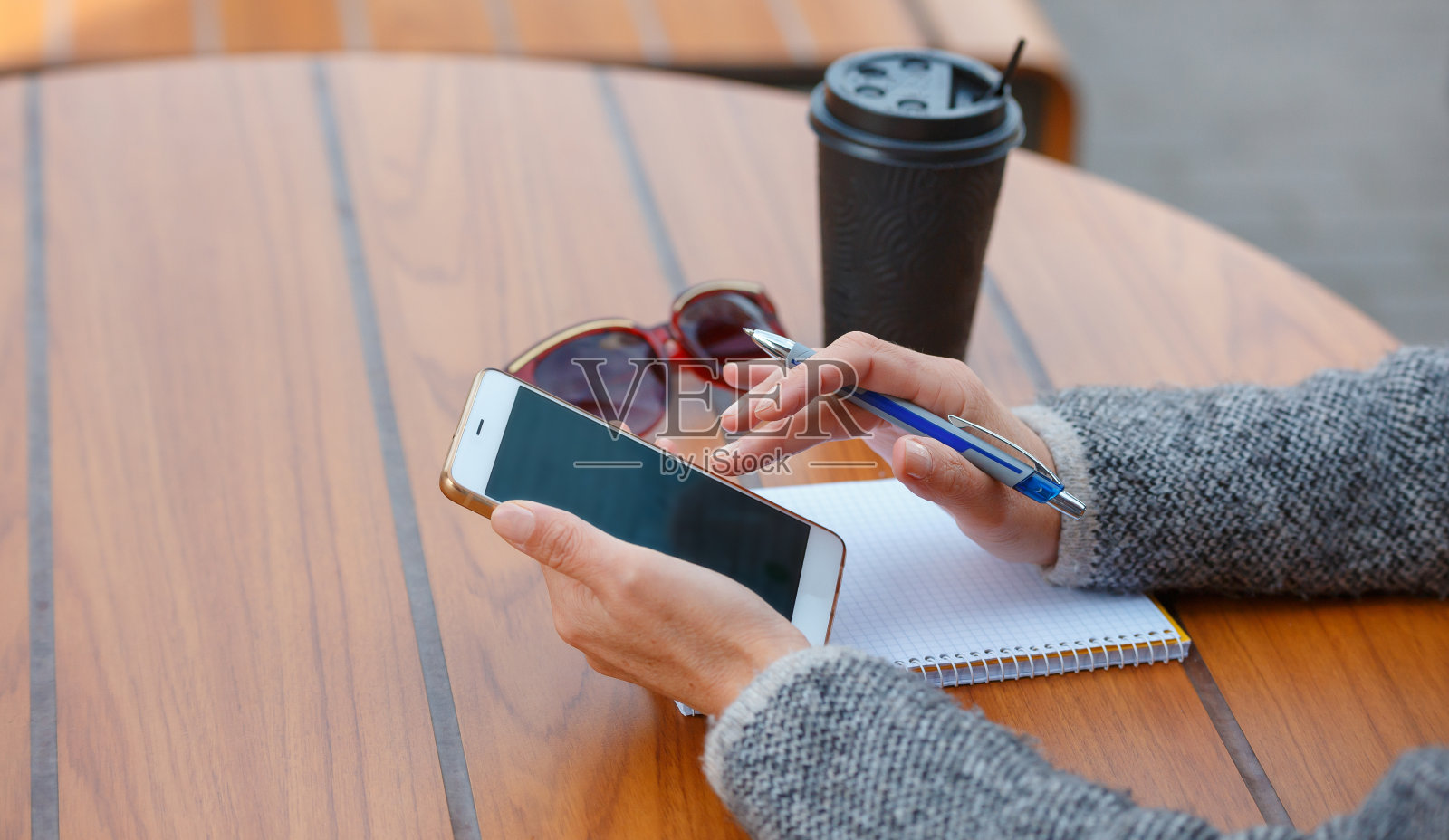 一个女人正坐在一家夏日咖啡馆的桌旁。照片摄影图片