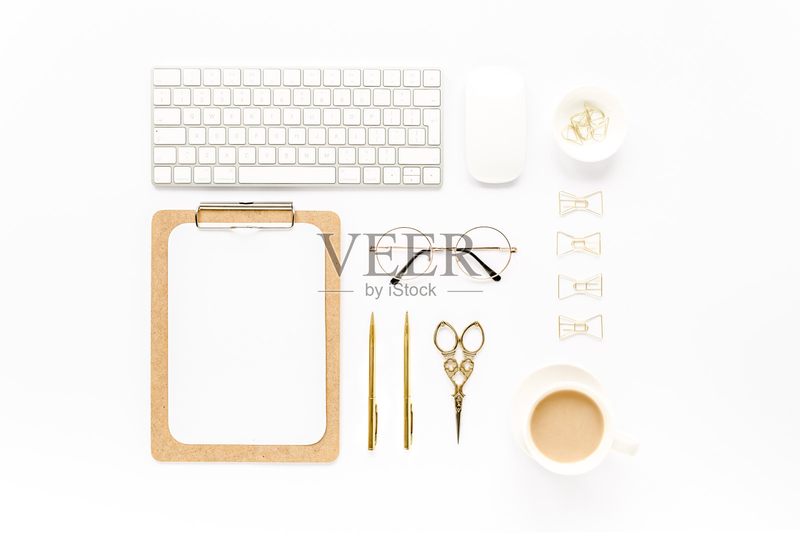 家庭办公的工作空间与电脑，剪贴板，笔记本电脑和金色的配件在白色的背景。平躺，俯视图照片摄影图片