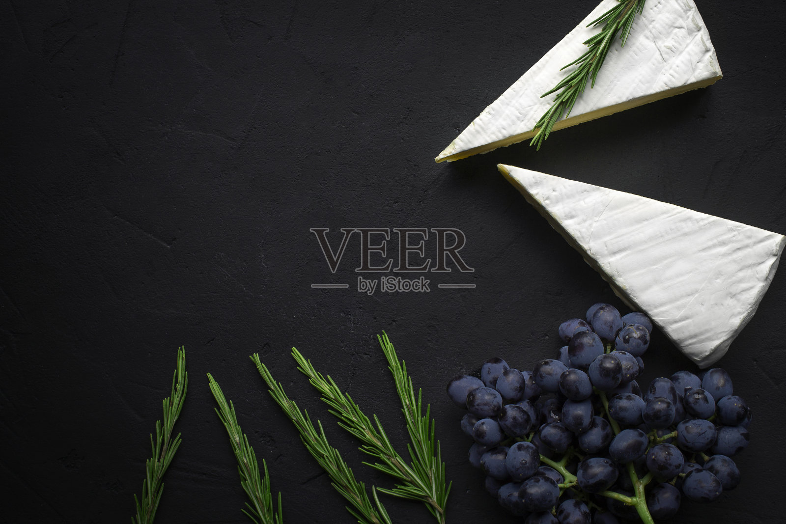 布里奶酪，黑色背景，香草和葡萄照片摄影图片