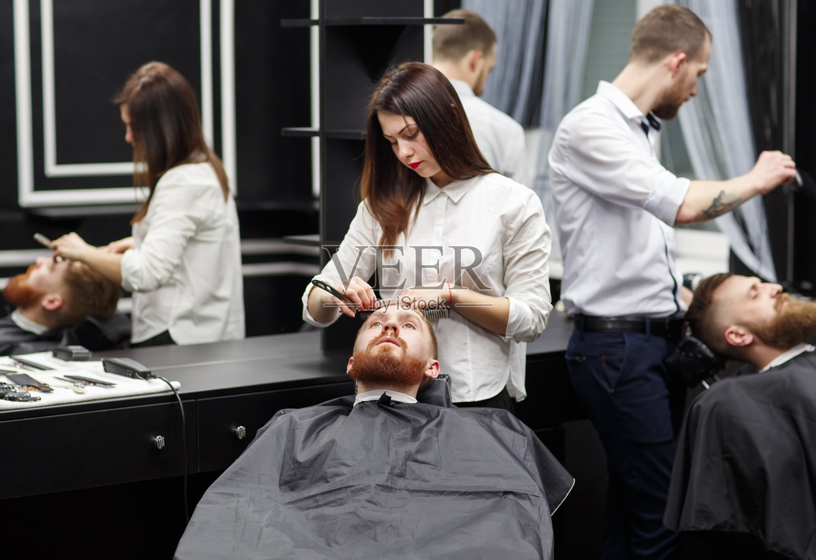 自信的男人在理发店里拜访发型师。照片摄影图片
