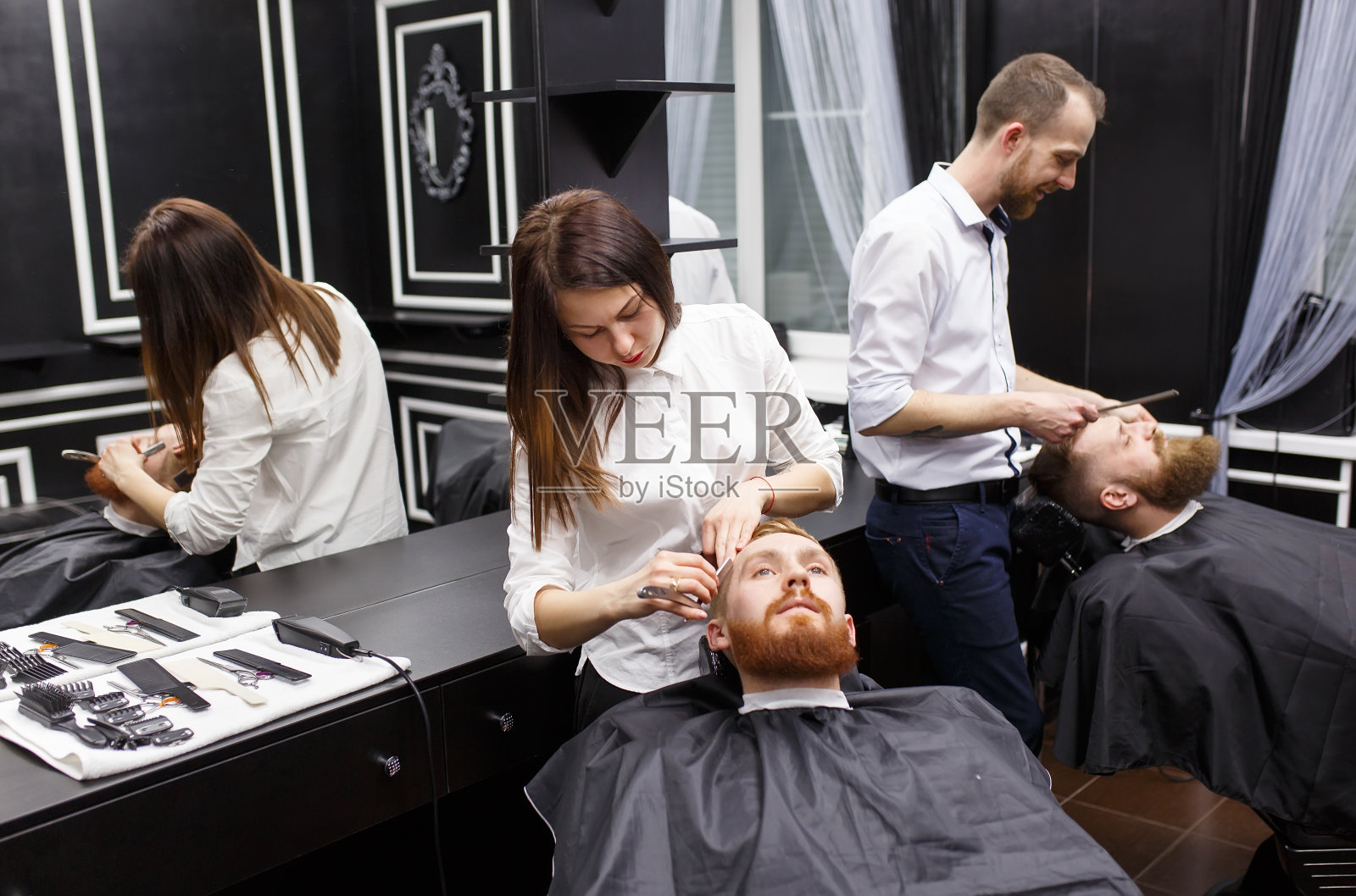 自信的男人在理发店里拜访发型师。照片摄影图片