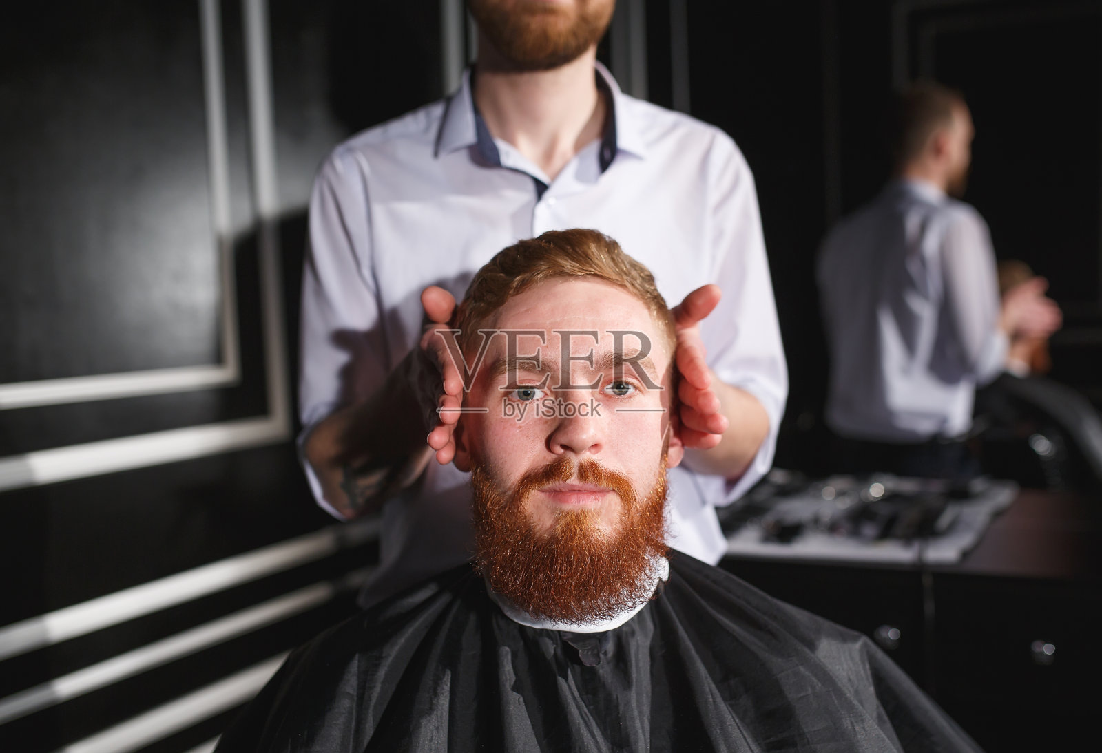 一个自信的男人在理发店里拜访发型师。照片摄影图片