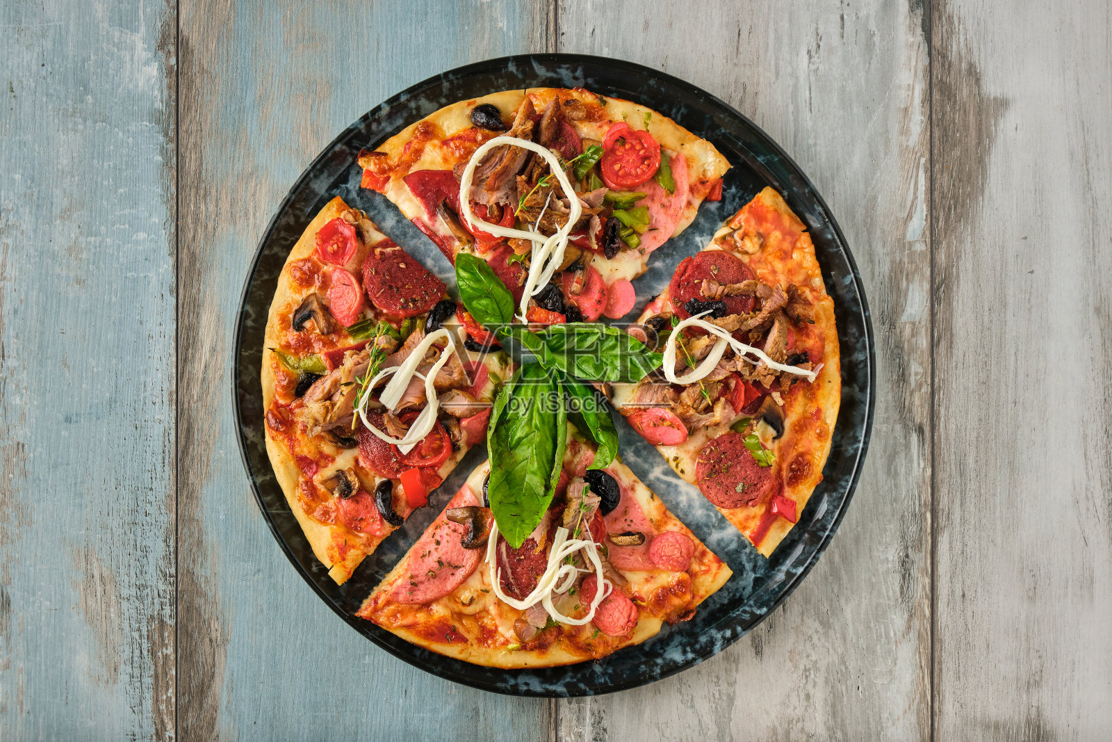 木制背景下俯视图的超级混合披萨照片摄影图片