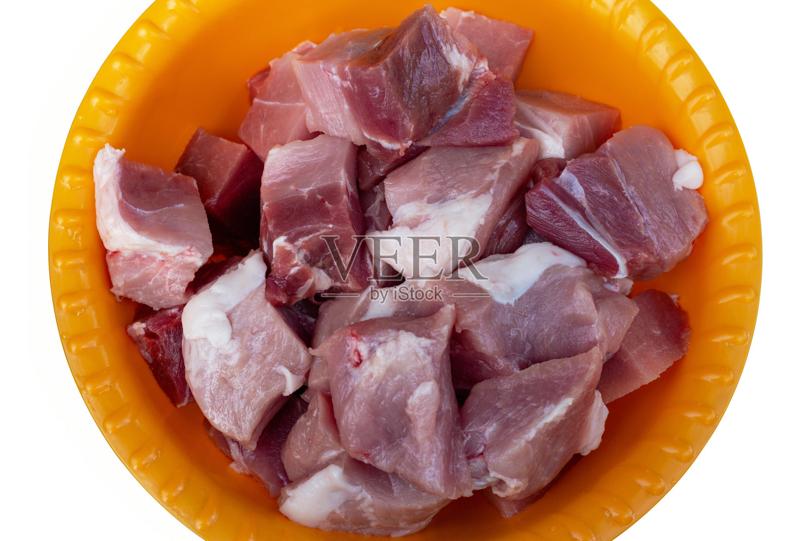 一块块的肉放在一个橙色的塑料碗里。孤立。前视图。照片摄影图片