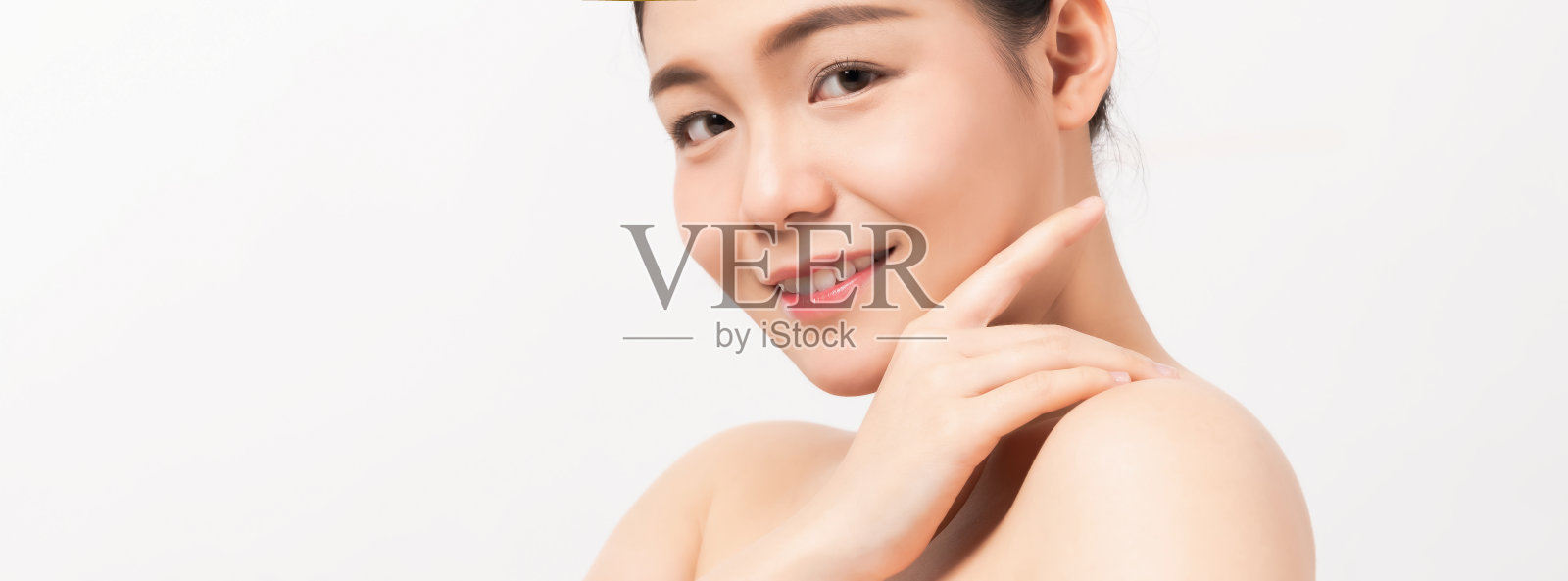 近距离的亚洲女性美丽的脸与干净的新鲜的皮肤，微笑与看起来美丽和健康。照片摄影图片