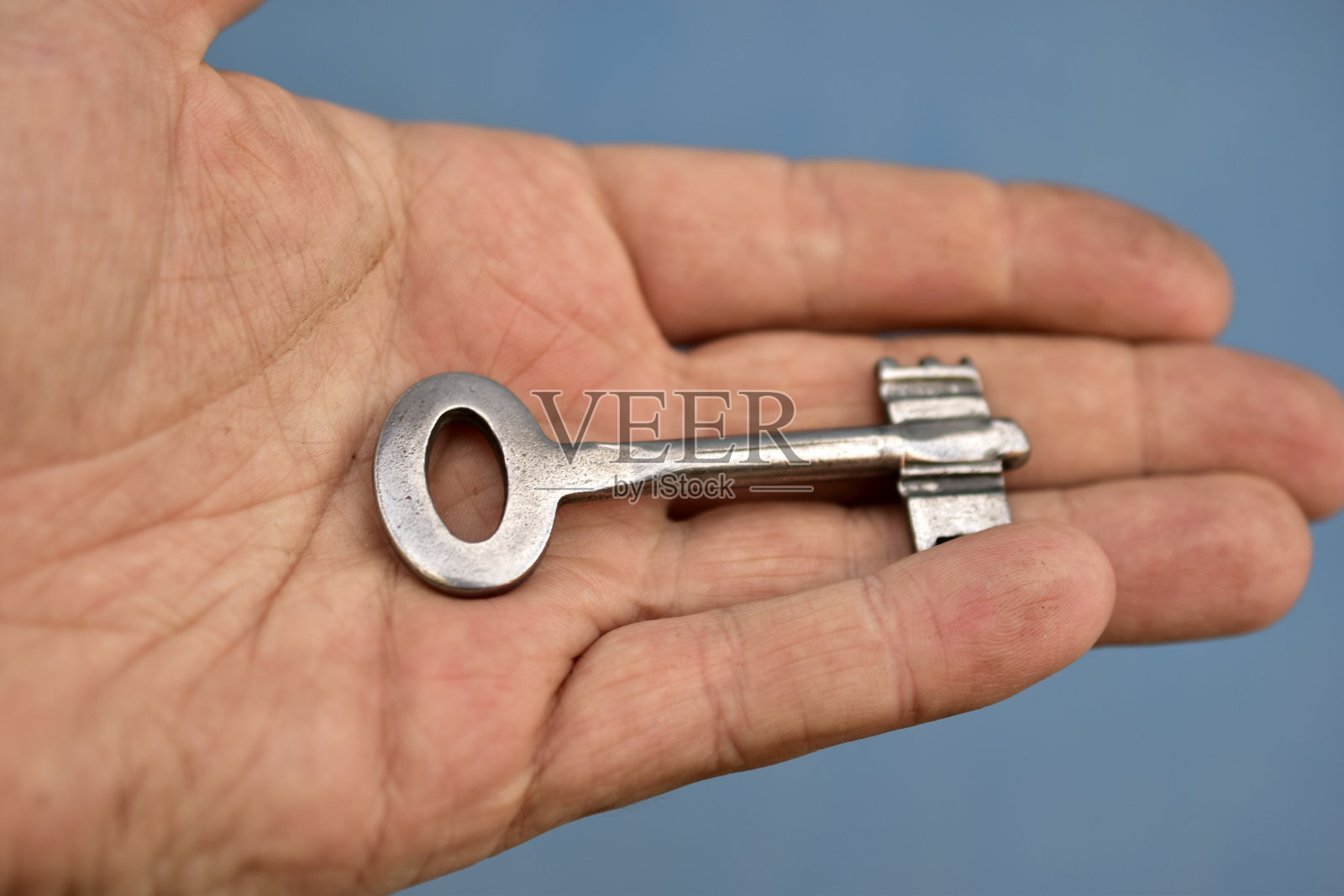 蓝色背景上的旧铁门钥匙照片摄影图片