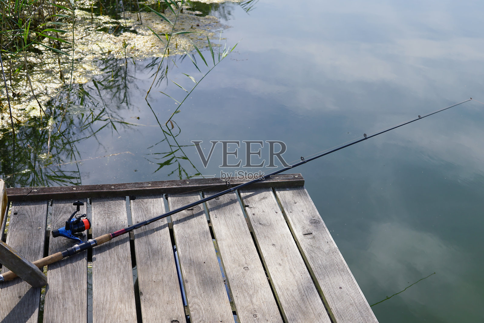 一个钓竿躺在湖上的木码头上照片摄影图片