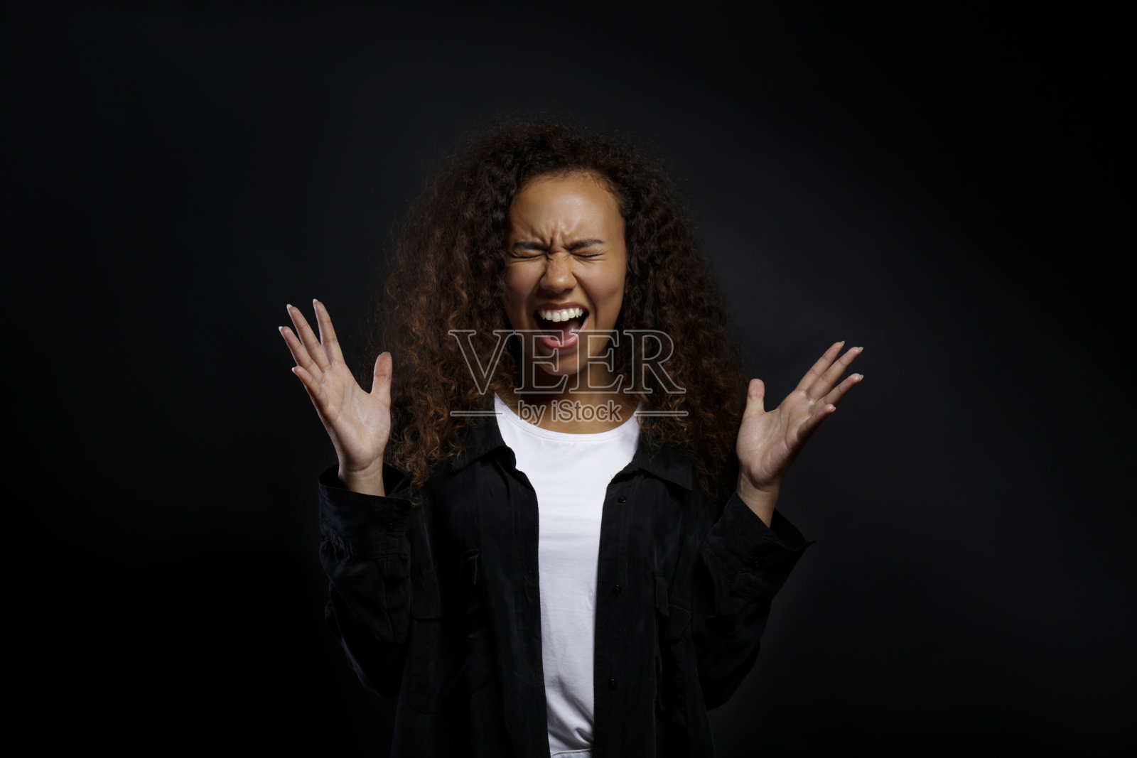 年轻的女子，有着卷曲的黑发，流露出情感。照片摄影图片