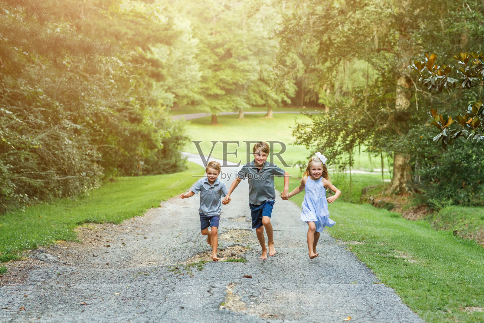 三个孩子在外面跑照片摄影图片