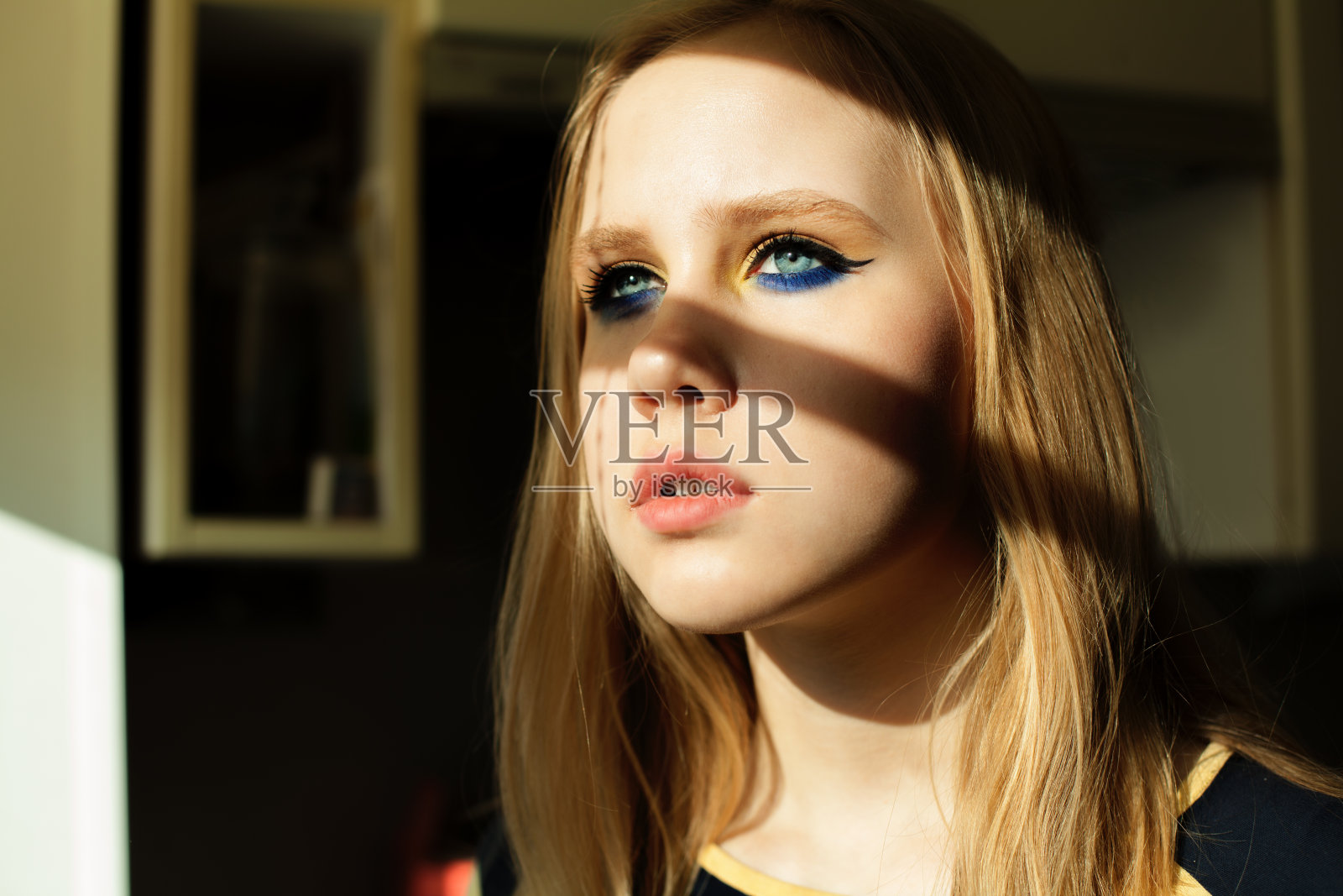 金发碧眼的漂亮女孩，在阳光和阴影下的妆容照片摄影图片