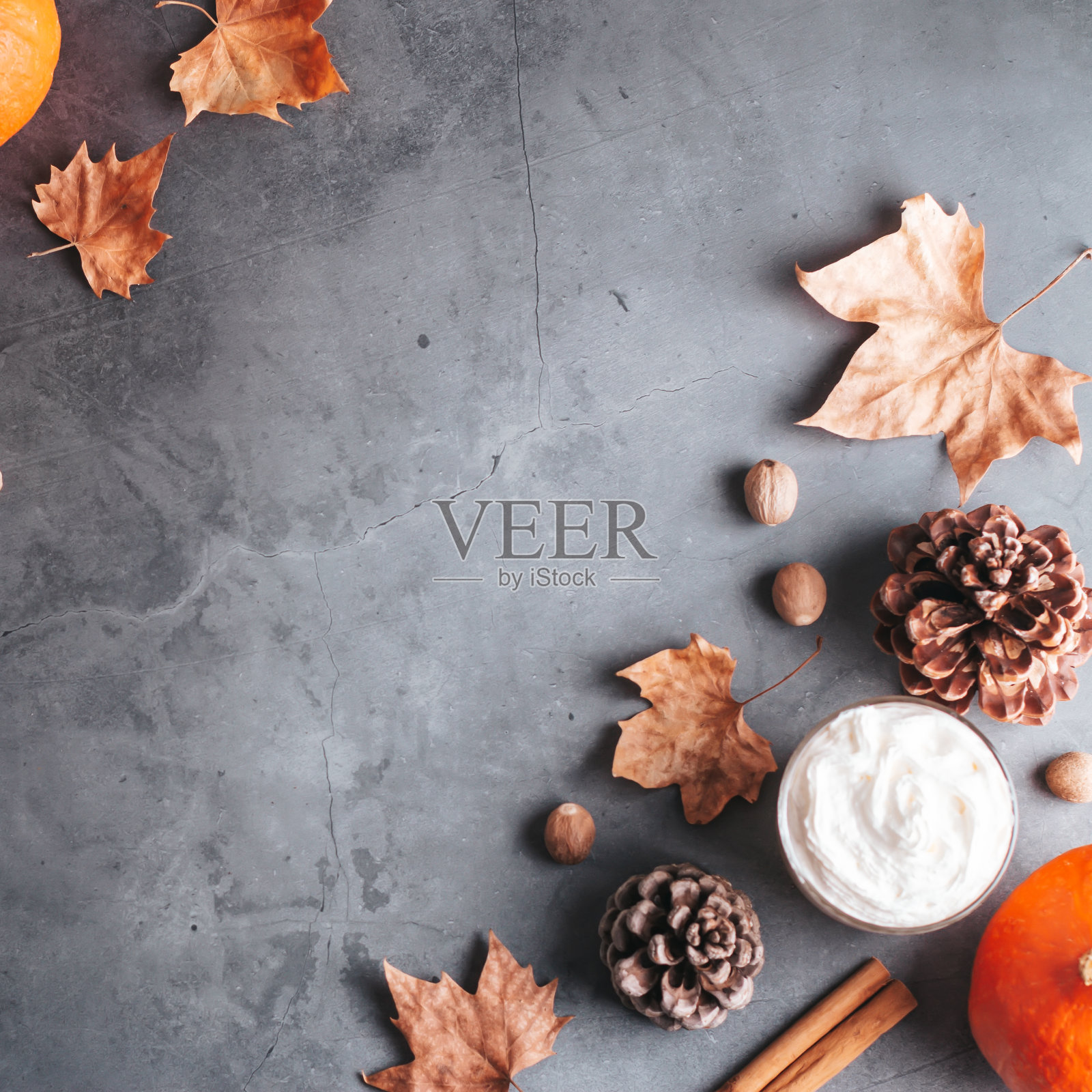 秋季框架与天然松果，南瓜，干叶和南瓜拿铁在深灰色的石头顶部，顶视图，拷贝空间。秋天，感恩的背景，惬意的平躺着照片摄影图片