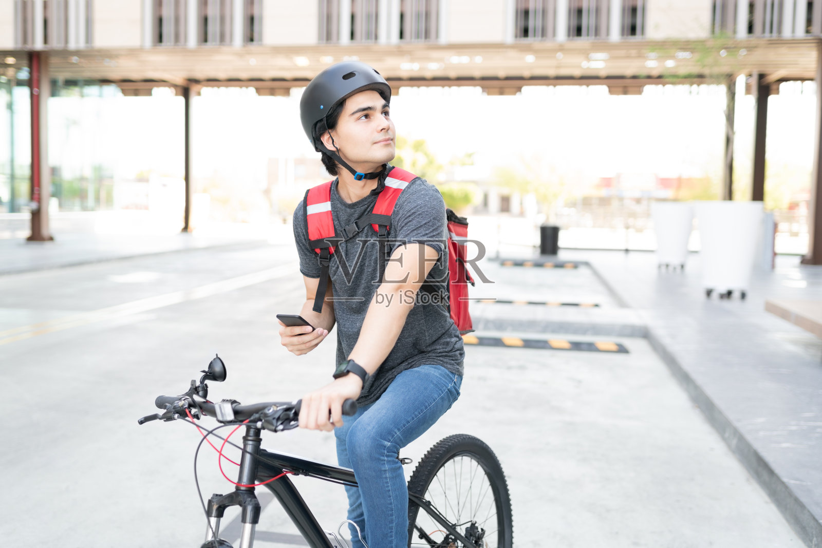 年轻的送货员在市里寻找地址照片摄影图片