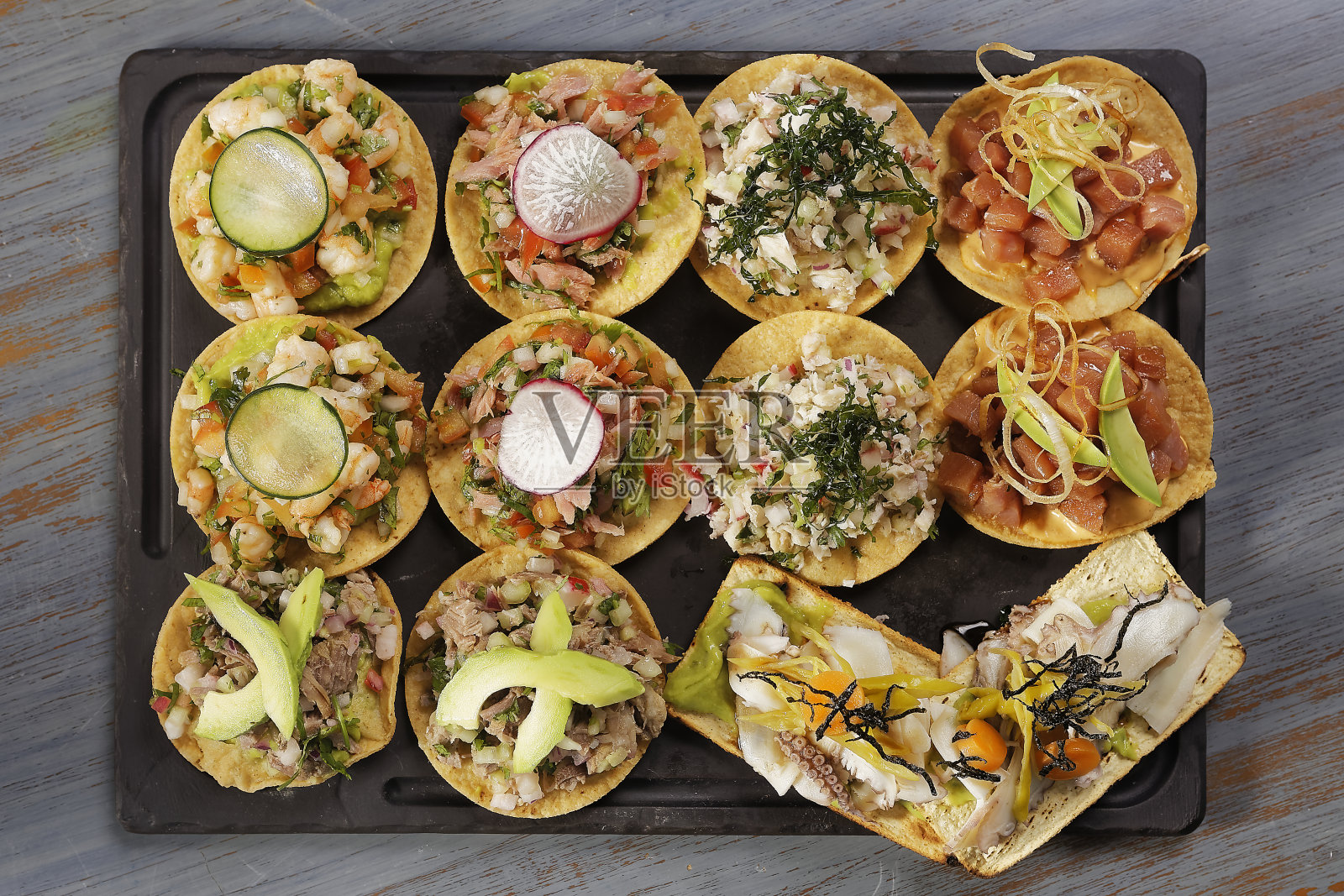 金枪鱼、虾和章鱼吐司零食配萝卜、黄瓜和鳄梨。照片摄影图片