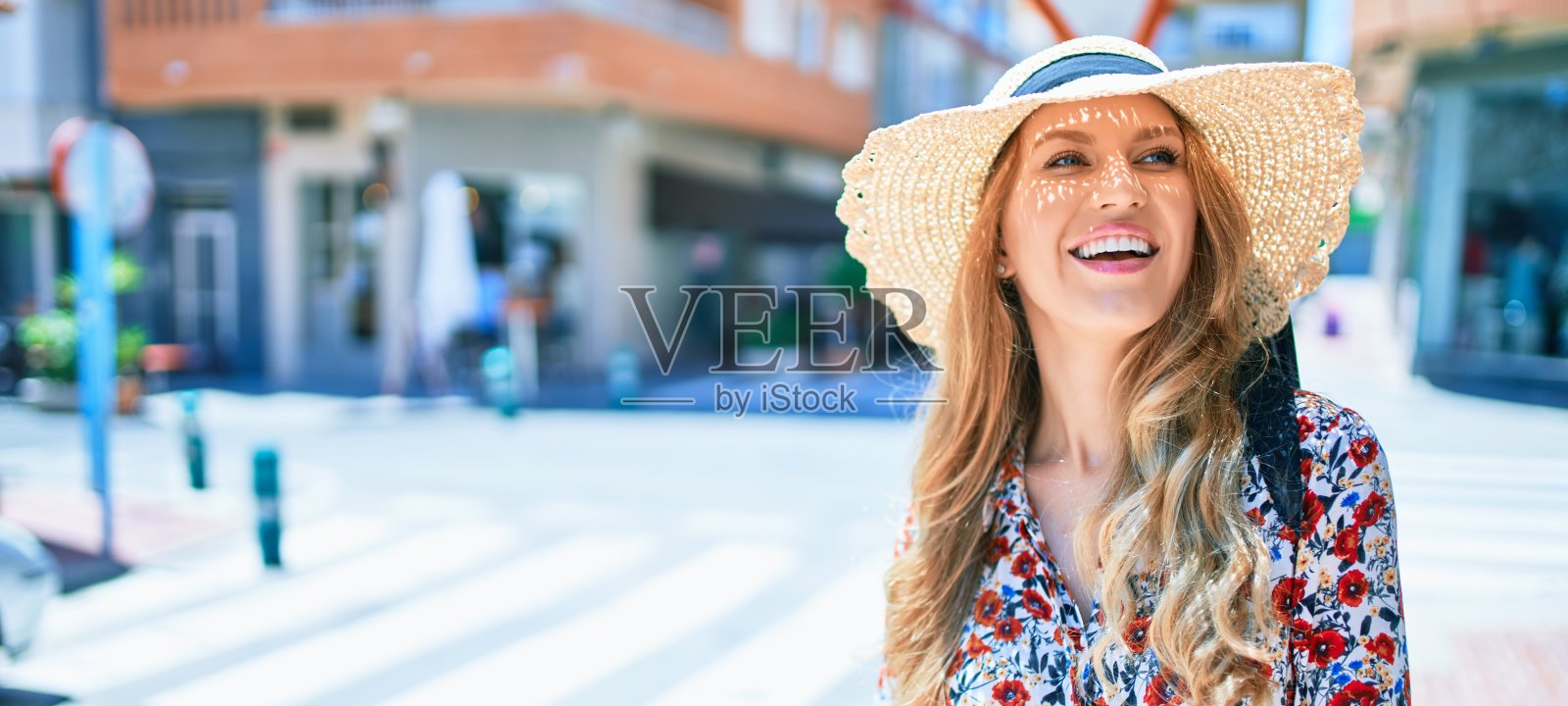 年轻美丽的金发女人度假戴着夏天的帽子微笑快乐。微笑着站在城市的街道上。照片摄影图片