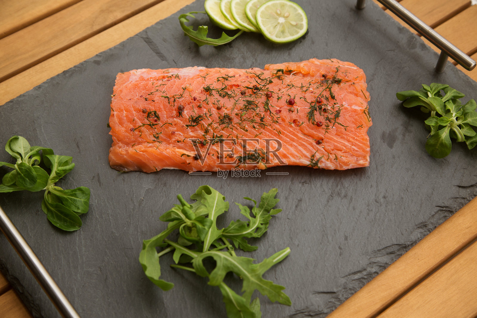 黑色背景上的一片淡盐鲑鱼特写。照片摄影图片