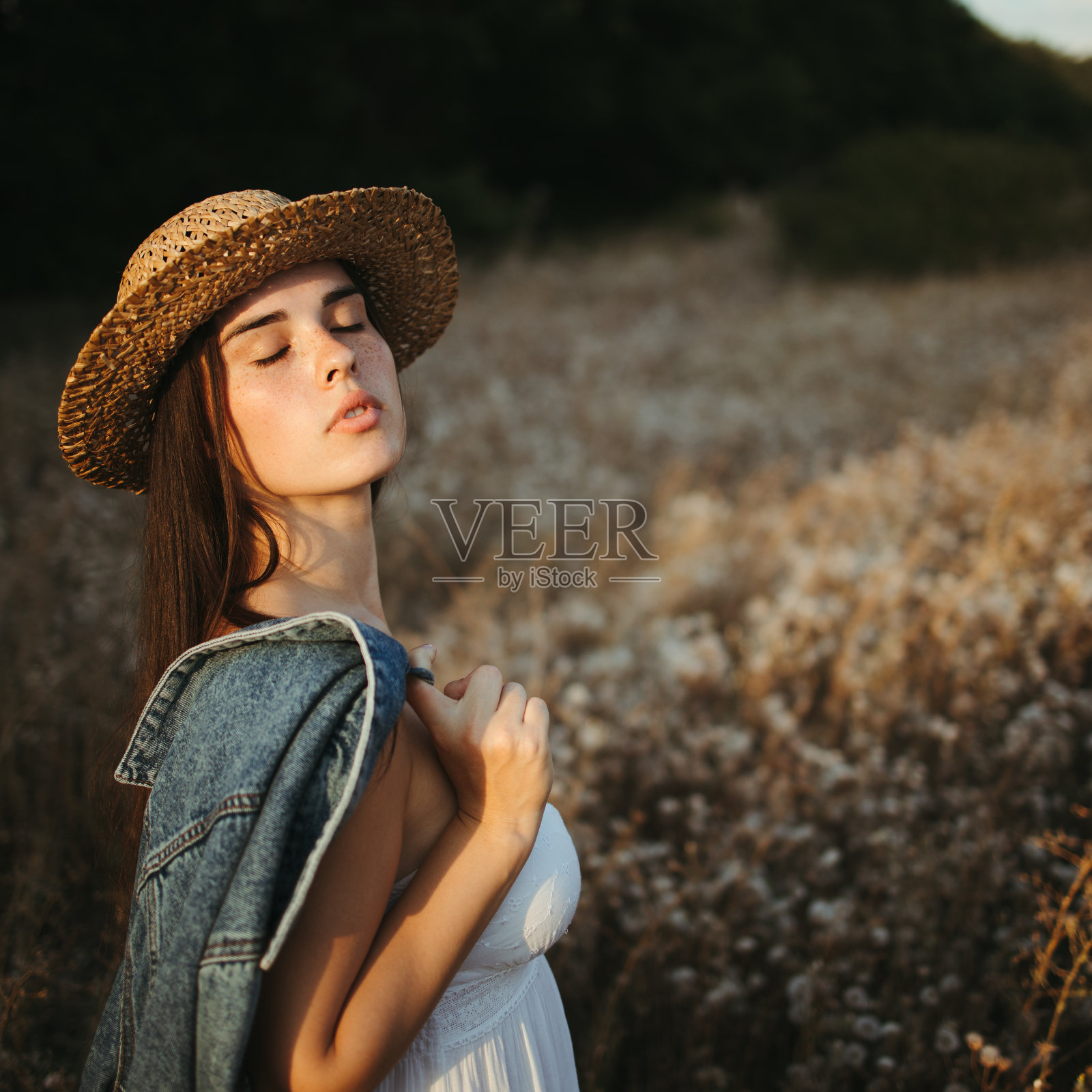 年轻可爱的长雀斑的女人走在夏日的草地上照片摄影图片