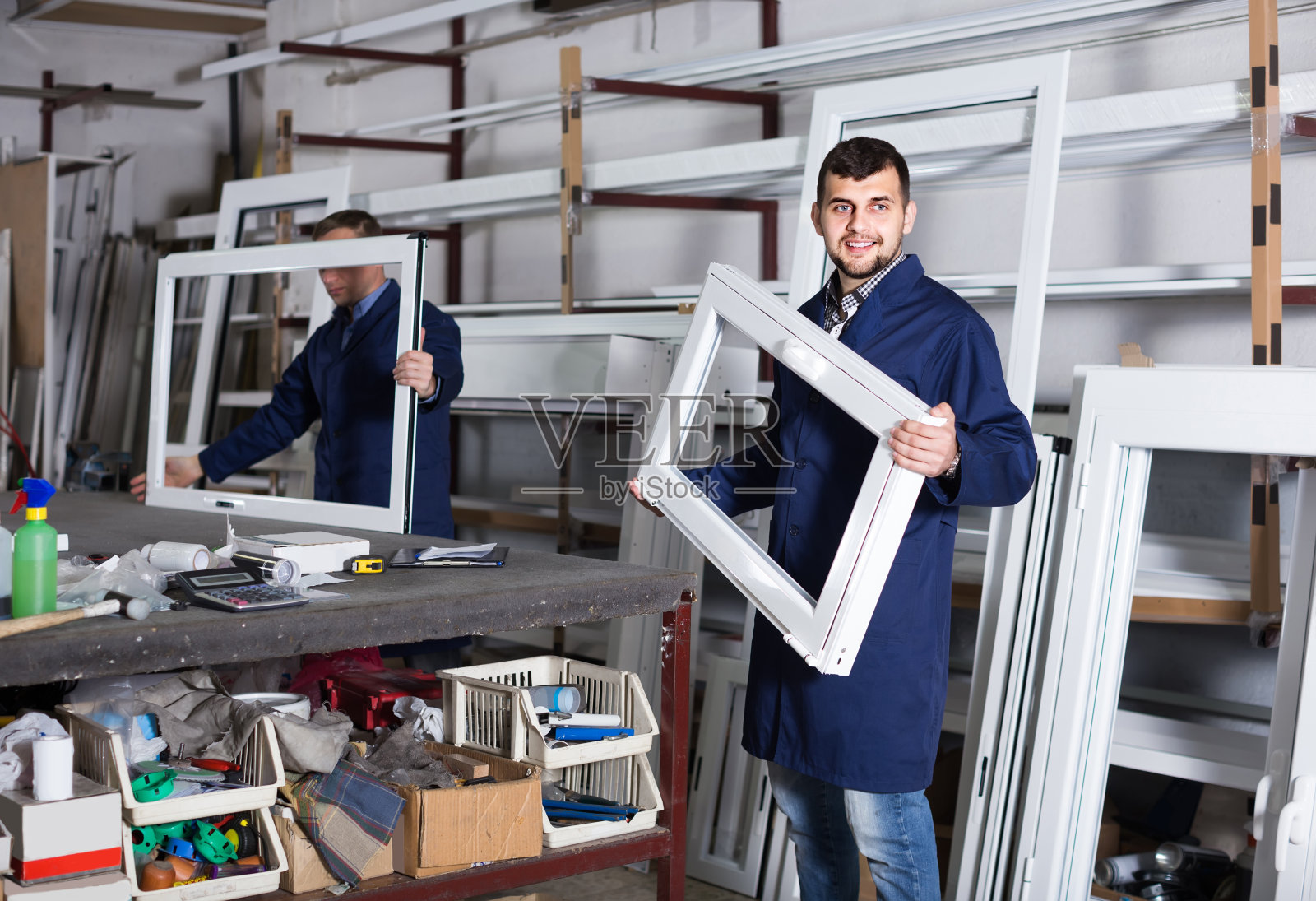 工厂内的生产工人使用不同成品的PVC型材和窗户照片摄影图片