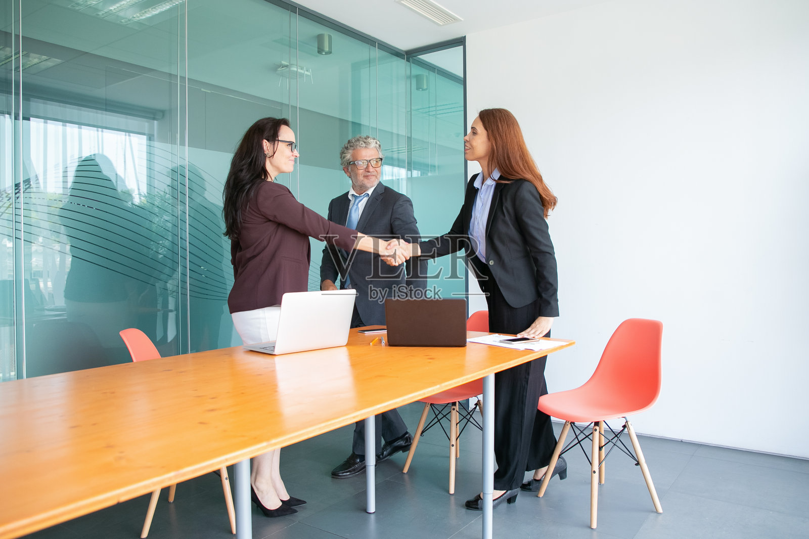 微笑的商务人士站在会议室开会照片摄影图片