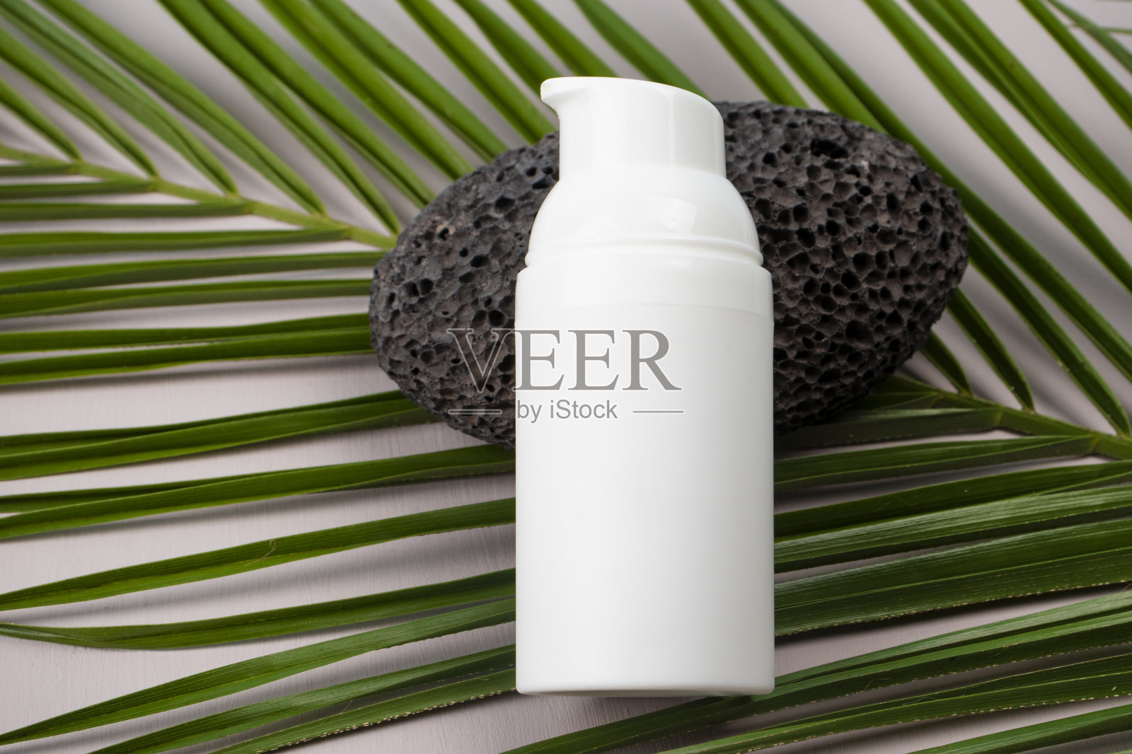 化妆品瓶容器与绿色草药叶子，空白标签的品牌模型，自然美容产品的概念。照片摄影图片