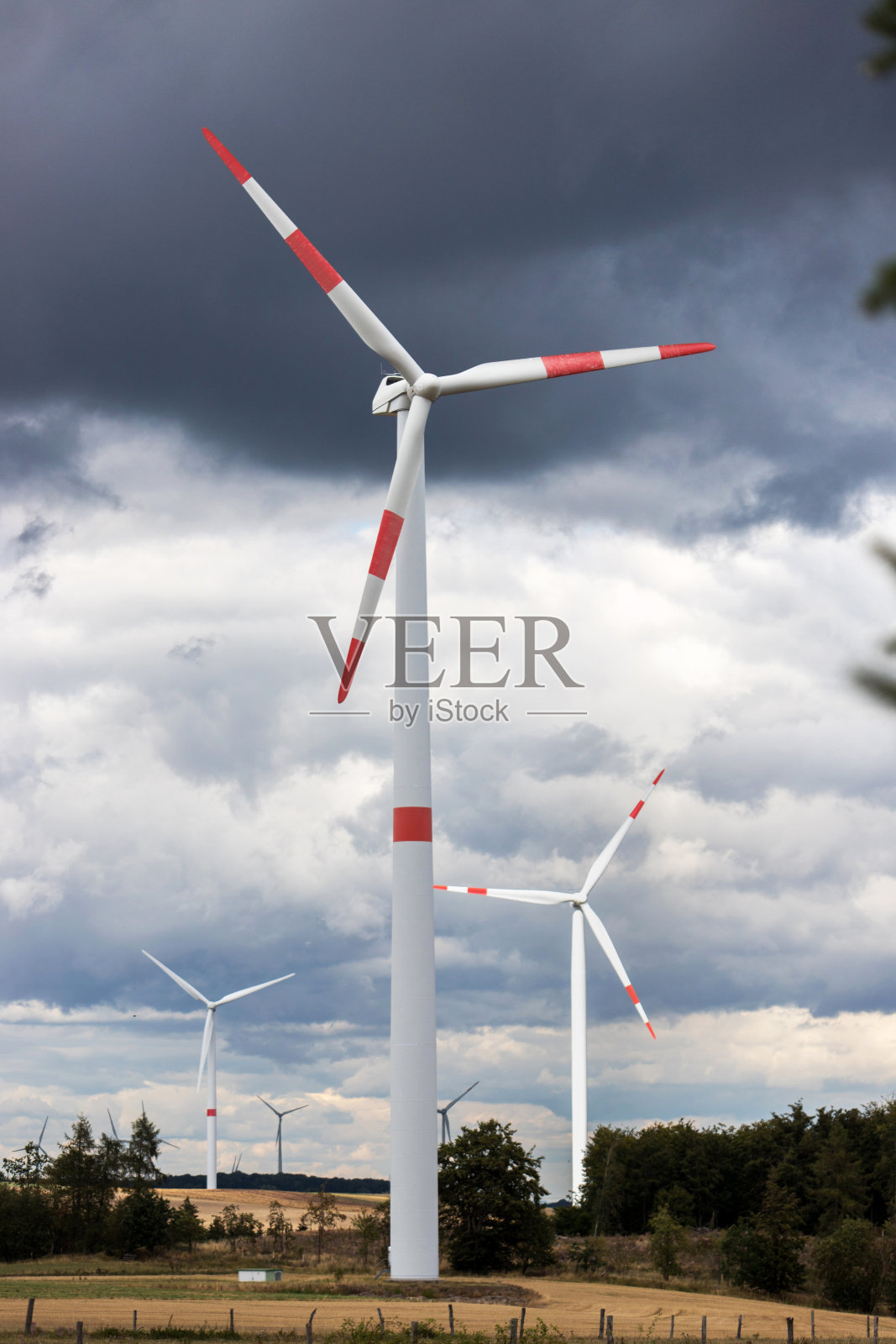 现代的风轮在多云的风暴面前形成垂直的天空景观照片摄影图片