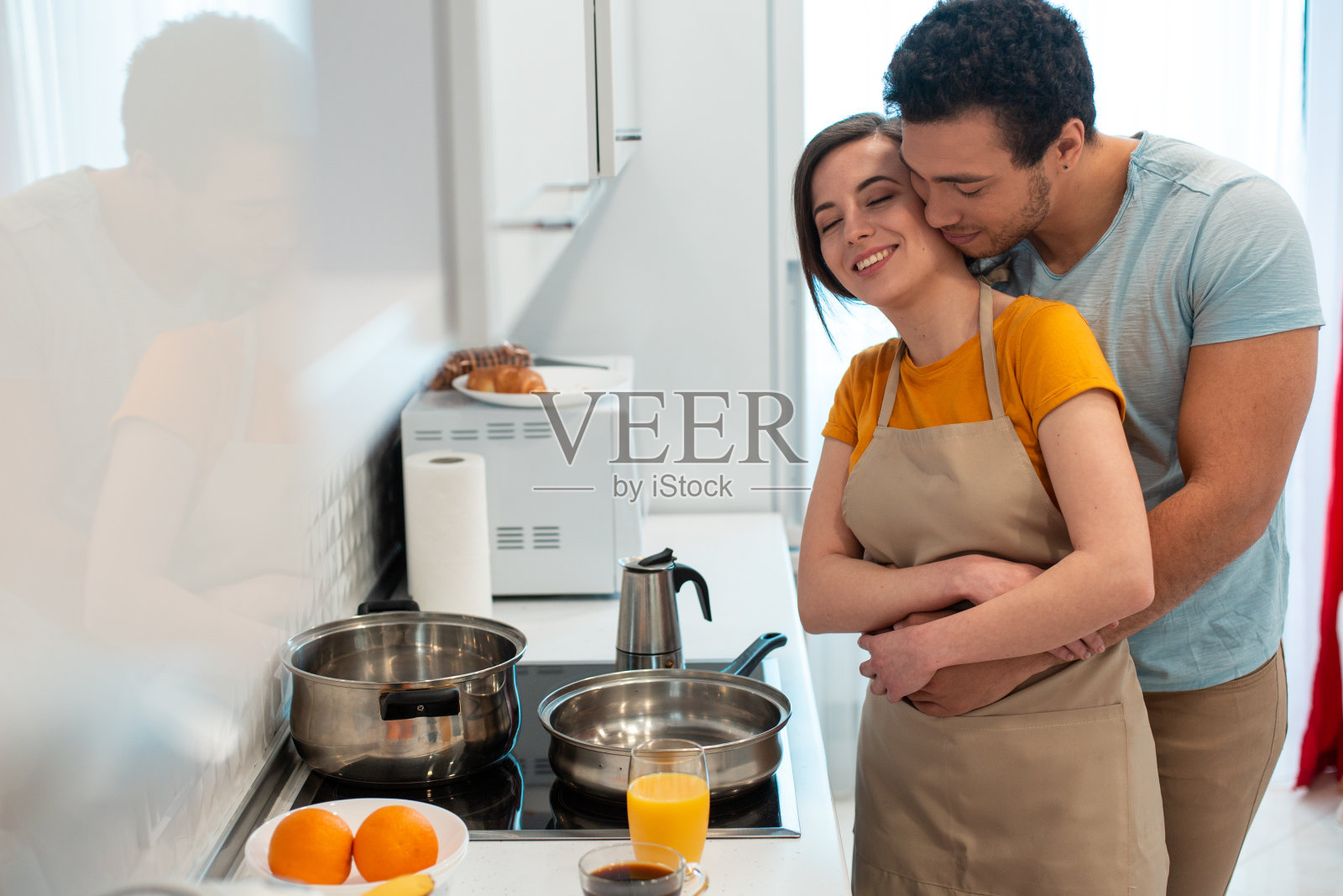 一对浪漫的情侣在家里的炊具旁拥抱照片摄影图片