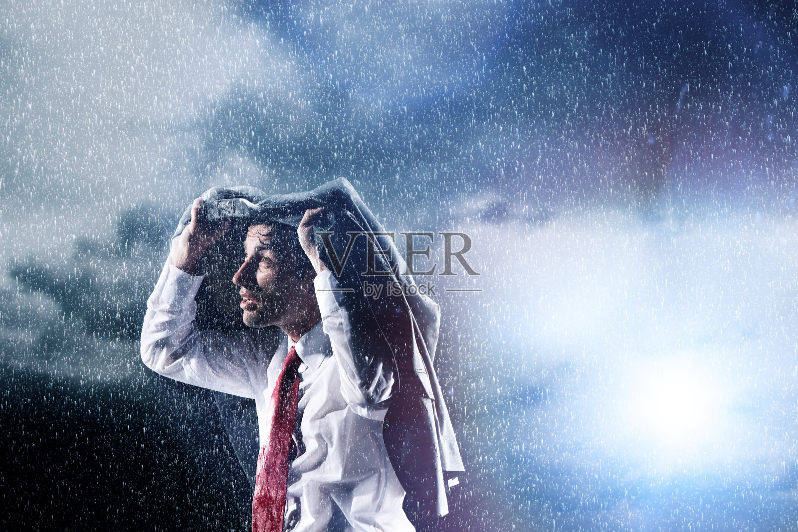 商人在大雨中藏在夹克里照片摄影图片