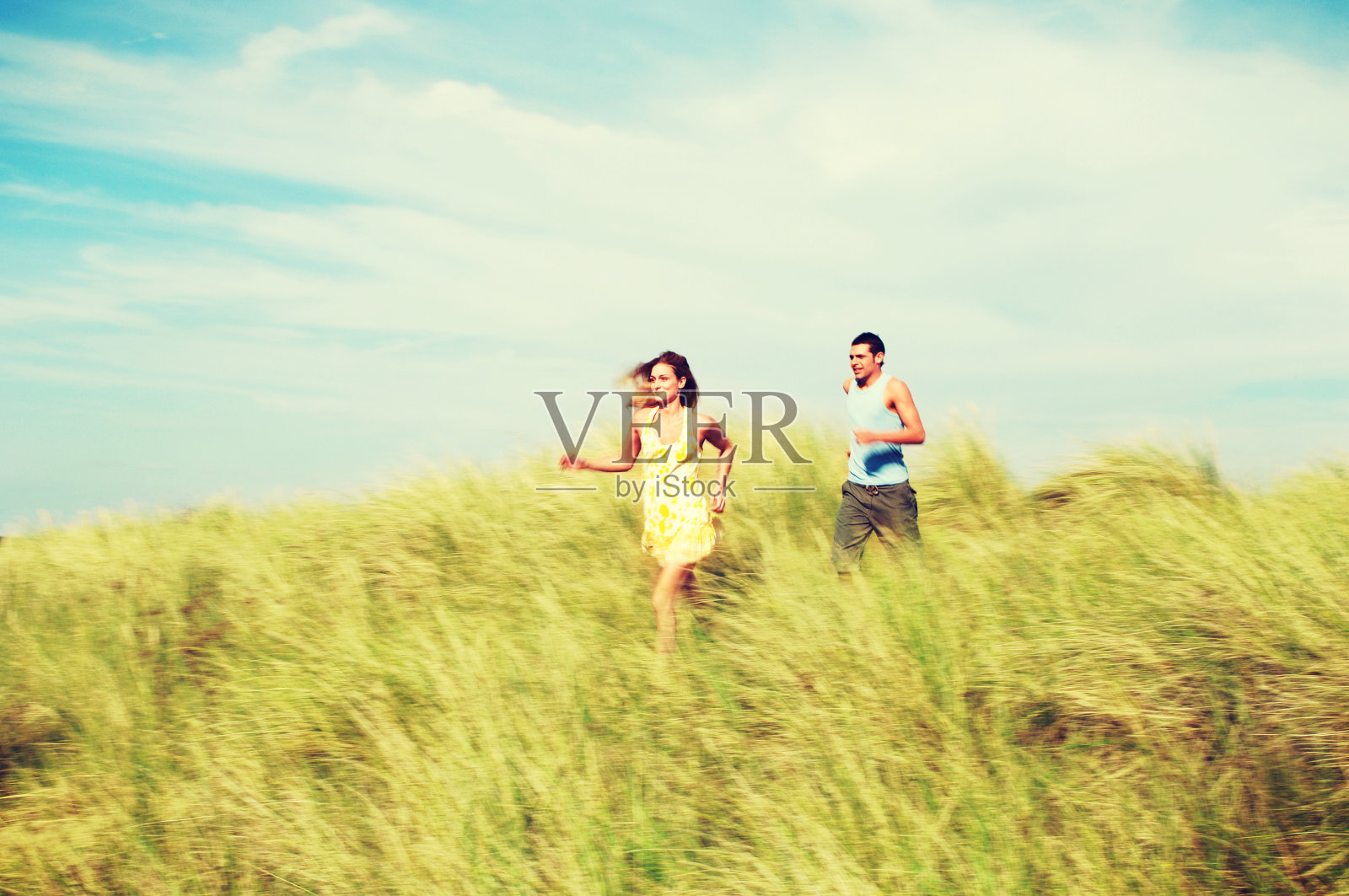 在草地上奔跑的夫妇照片摄影图片
