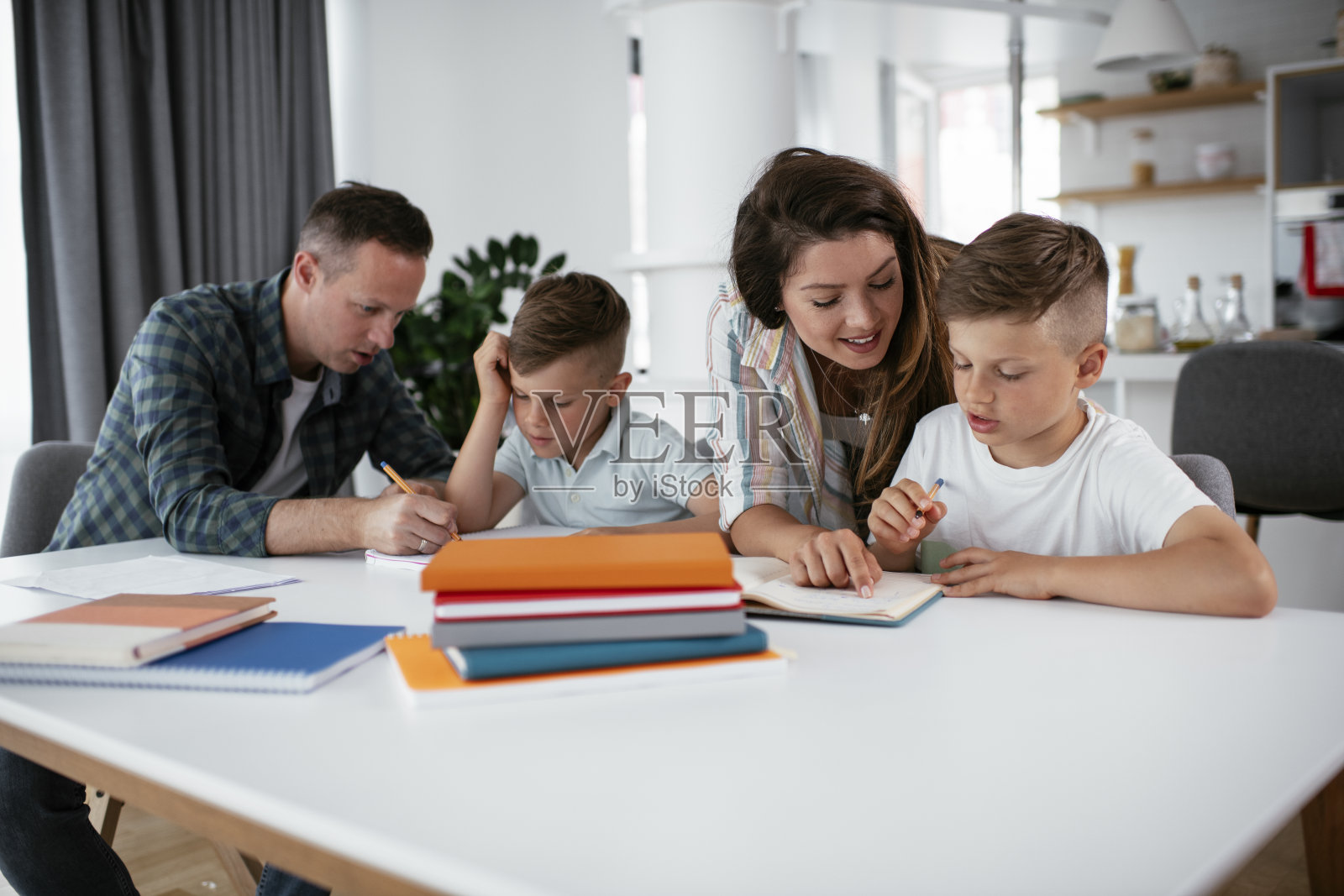父母帮助孩子们做作业照片摄影图片