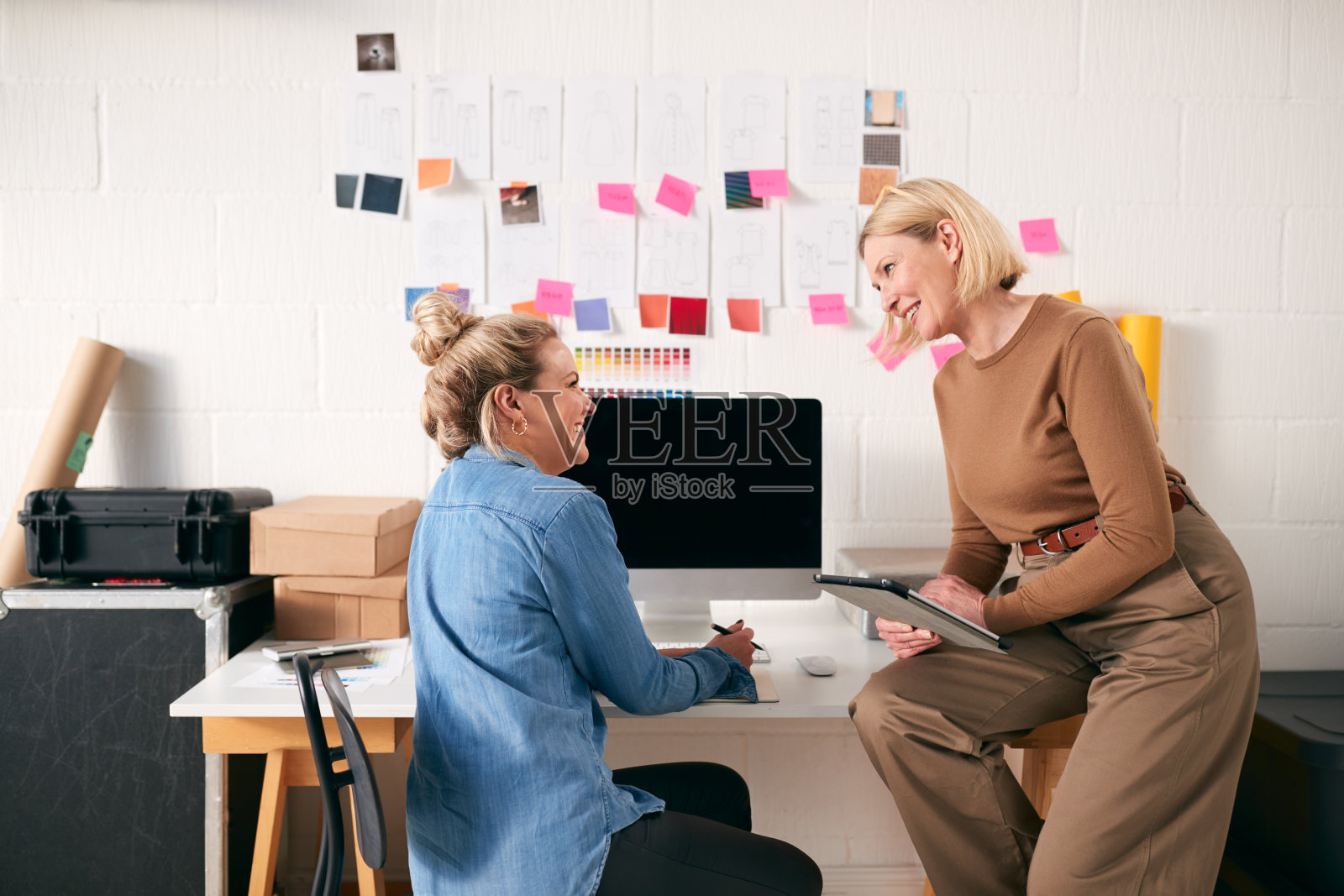 两个女人在工作室里一起在桌子上工作照片摄影图片