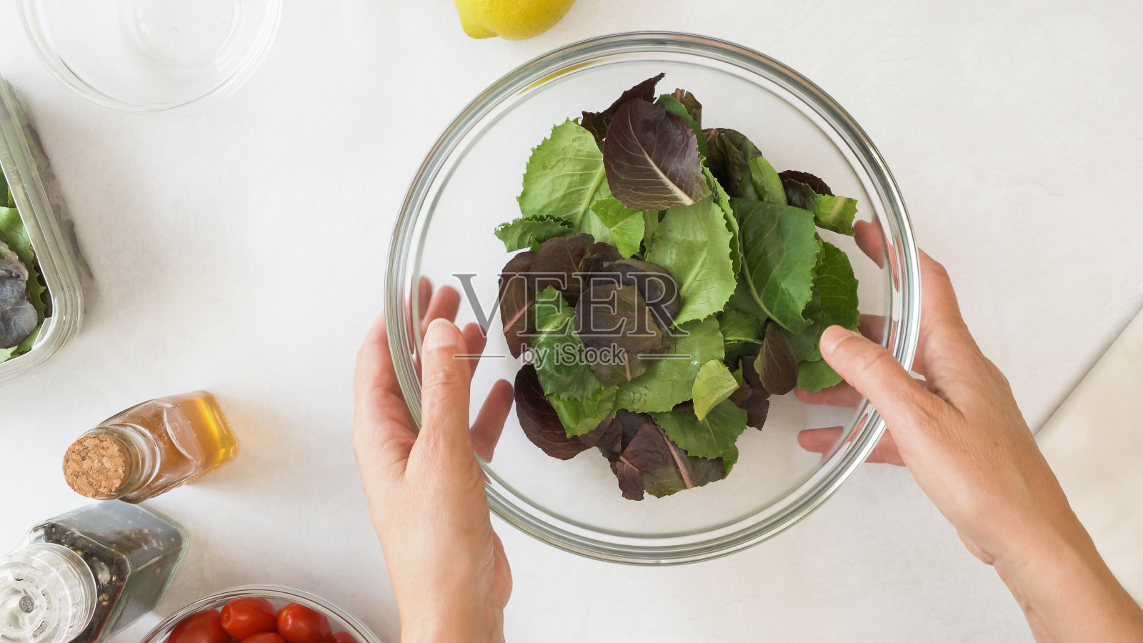 生菜沙拉放在一个玻璃碗里，靠近厨房的桌子，从上面看照片摄影图片