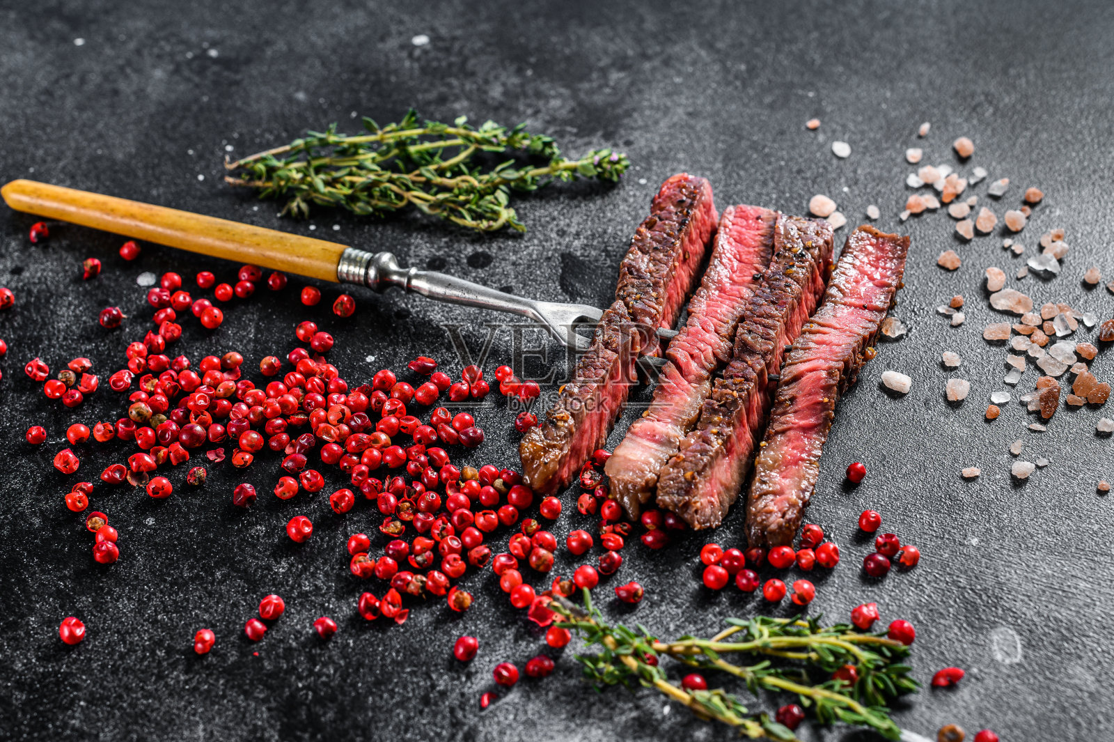 烤肋眼牛排加香料。烧烤牛肉。黑色背景。俯视图照片摄影图片